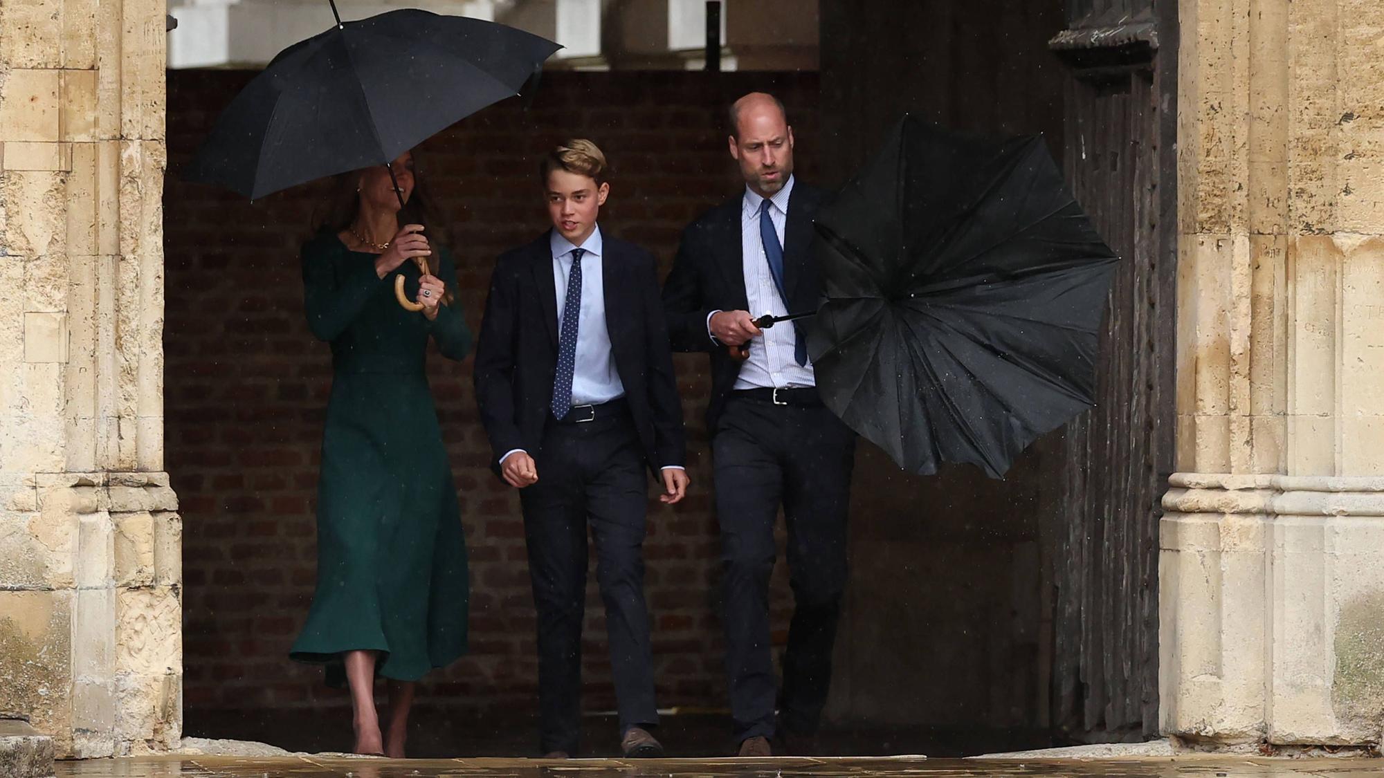 Prinz William (r.) müht sich mit seinem Regenschirm ab, während er gemeinsam mit Prinzessin Kate (l.) den 13-jährigen Prinz George (M.) zu dessen erstem Schultag am Eton College begleitet.