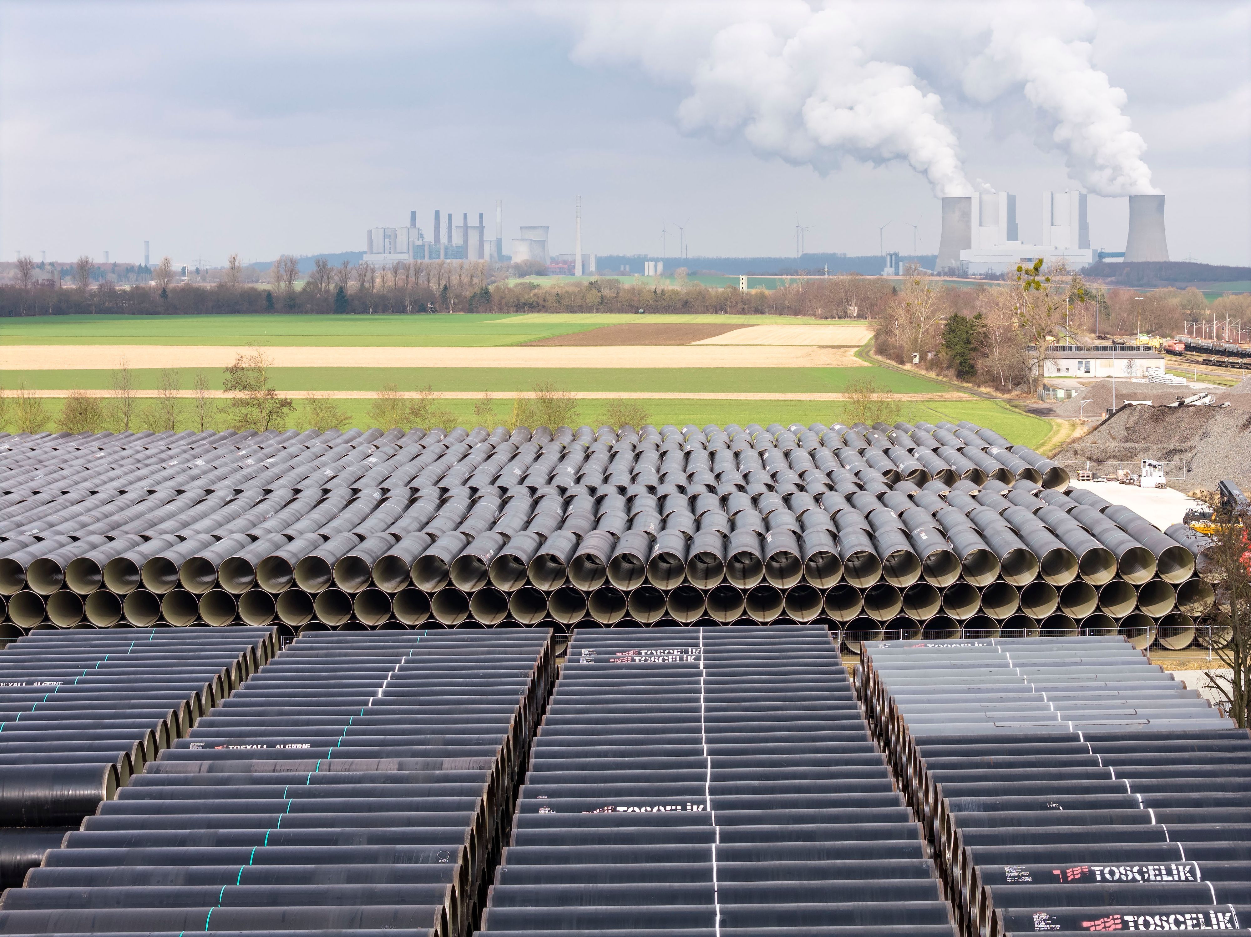 Am Kraftwerk Niederaußem lagern tausende Rohre für die Rheinwassertransportleitung, die nach und nach per Lkw zum Bauplatz transportiert werden.
