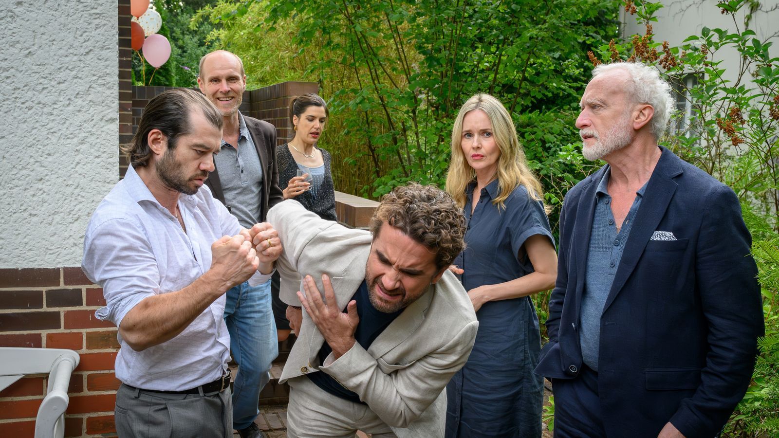 Galinas Bruder Andrej (Nikolas Garin, links) und ihr Vater Gennadij (Grigory Kofman, rechts) finden, dass Markus (Oliver Wnuk, Mitte) wissen muss, wie ein „echter Mann“ seine Frau verteidigt. Hape (Niels Bormann), Miriam (Stefanie Stappenbeck, zweite von rechts) und Andrea (Sophia Mercedes Burtscher) sind skeptisch. (Bild: ZDF/Marc Meyerbröker)