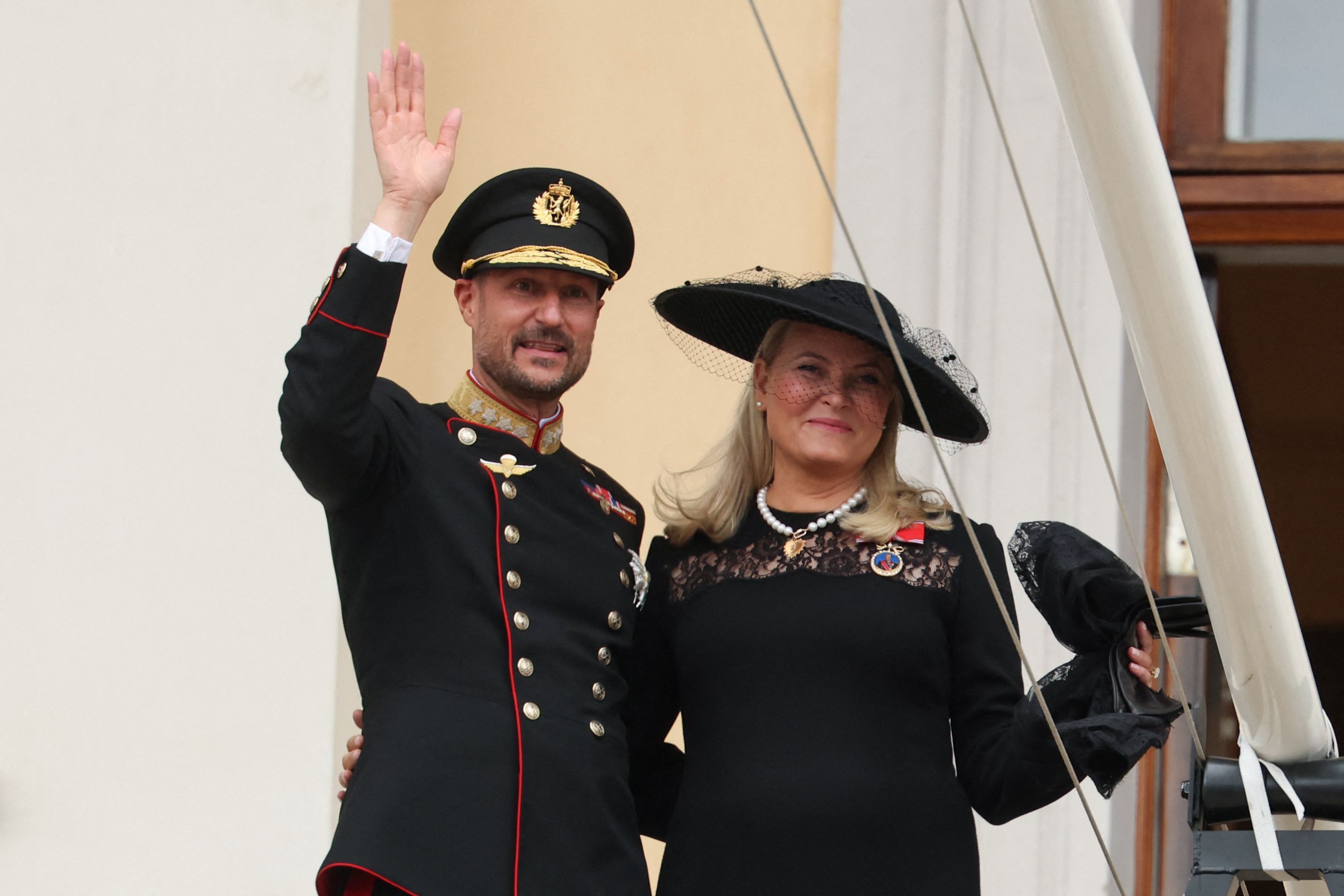 Trotz der Tränen lächeln König Haakon VIII. und Königin Mette-Marit auf dem Balkon des Osloer Schlosses den applaudierenden Menschen zu.