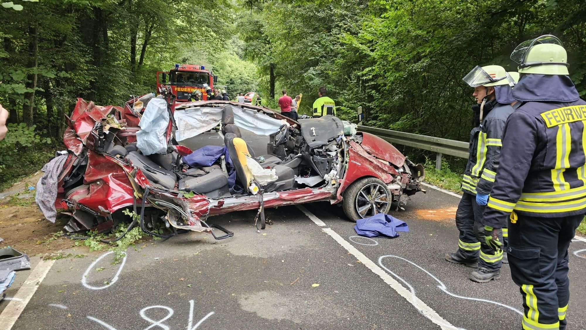 Ein Autowrack steht auf der Dürschtalstraße, Feuerwehrleute stehen daneben.
