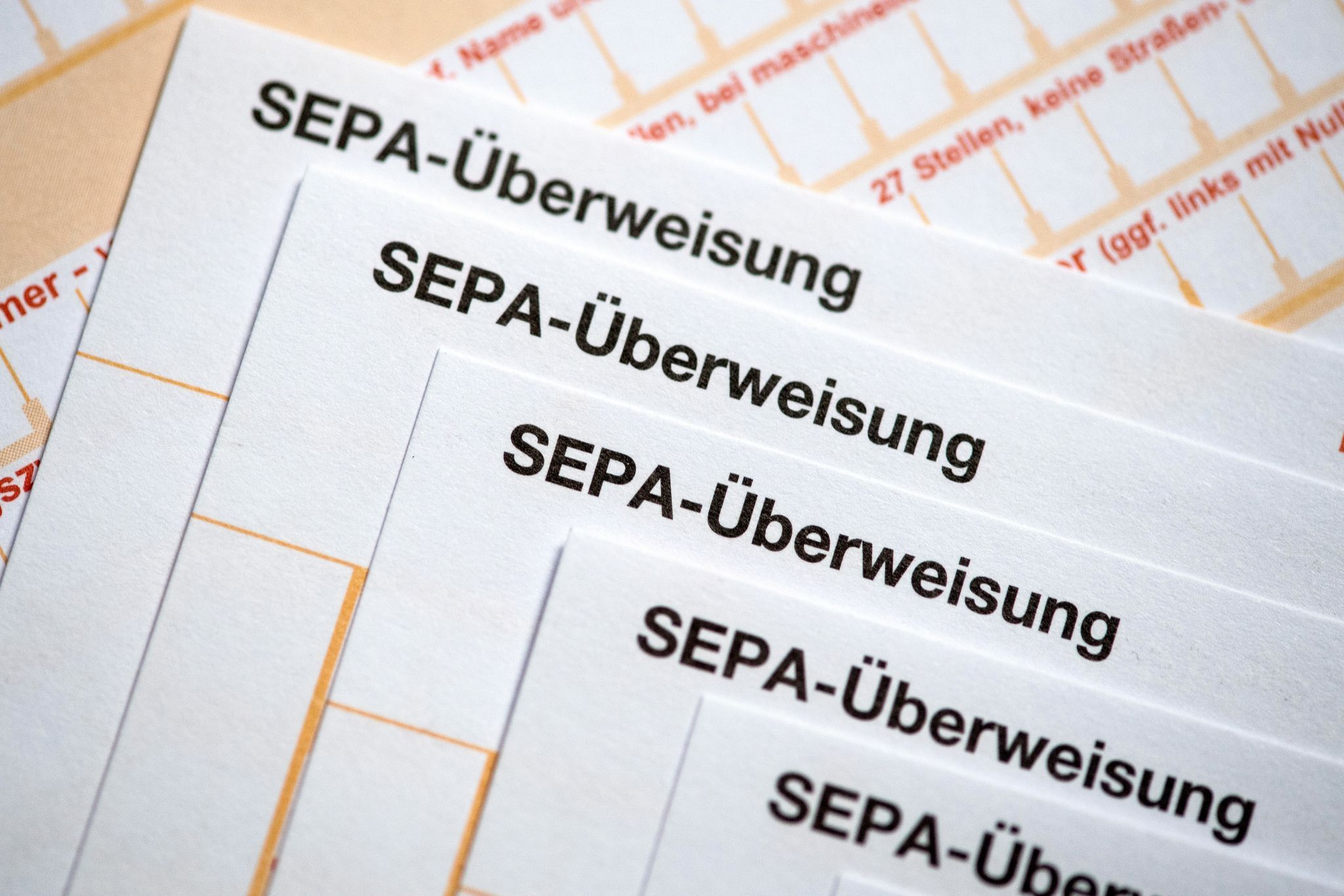 SEPA-Überweisungsscheine liegen auf einem Tisch