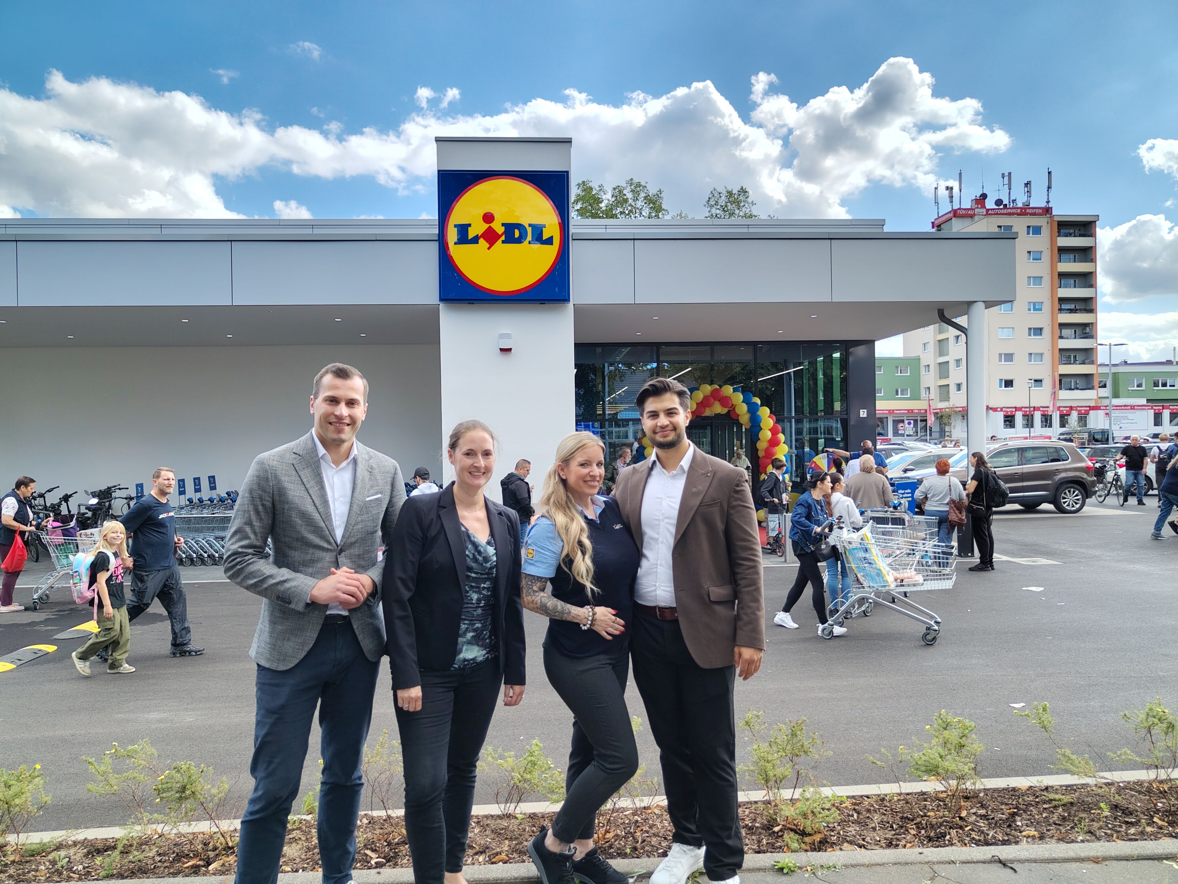 Vier Personen stehen vor einer Lidl-Filiale