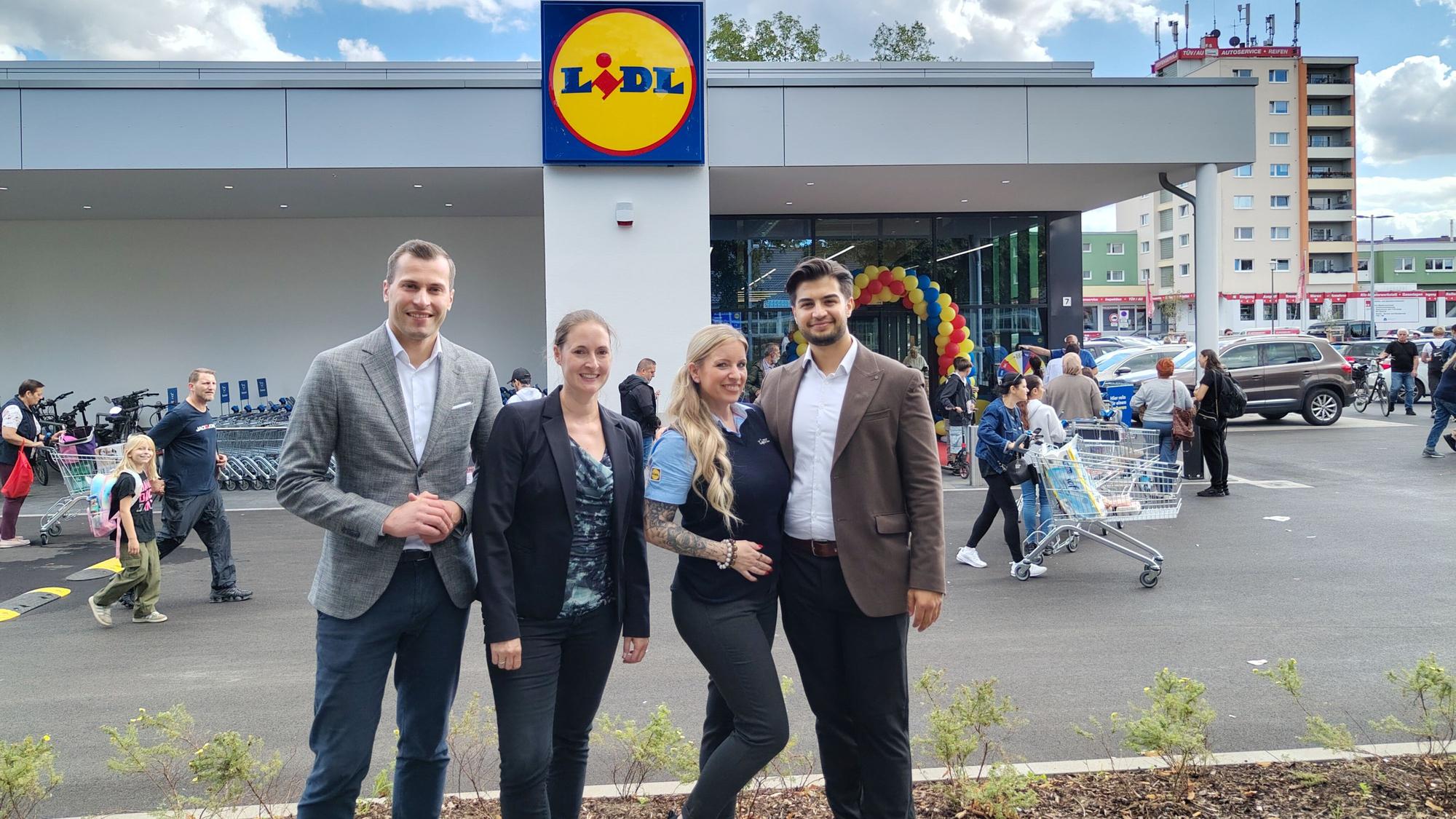 Vier Personen stehen vor einer Lidl-Filiale