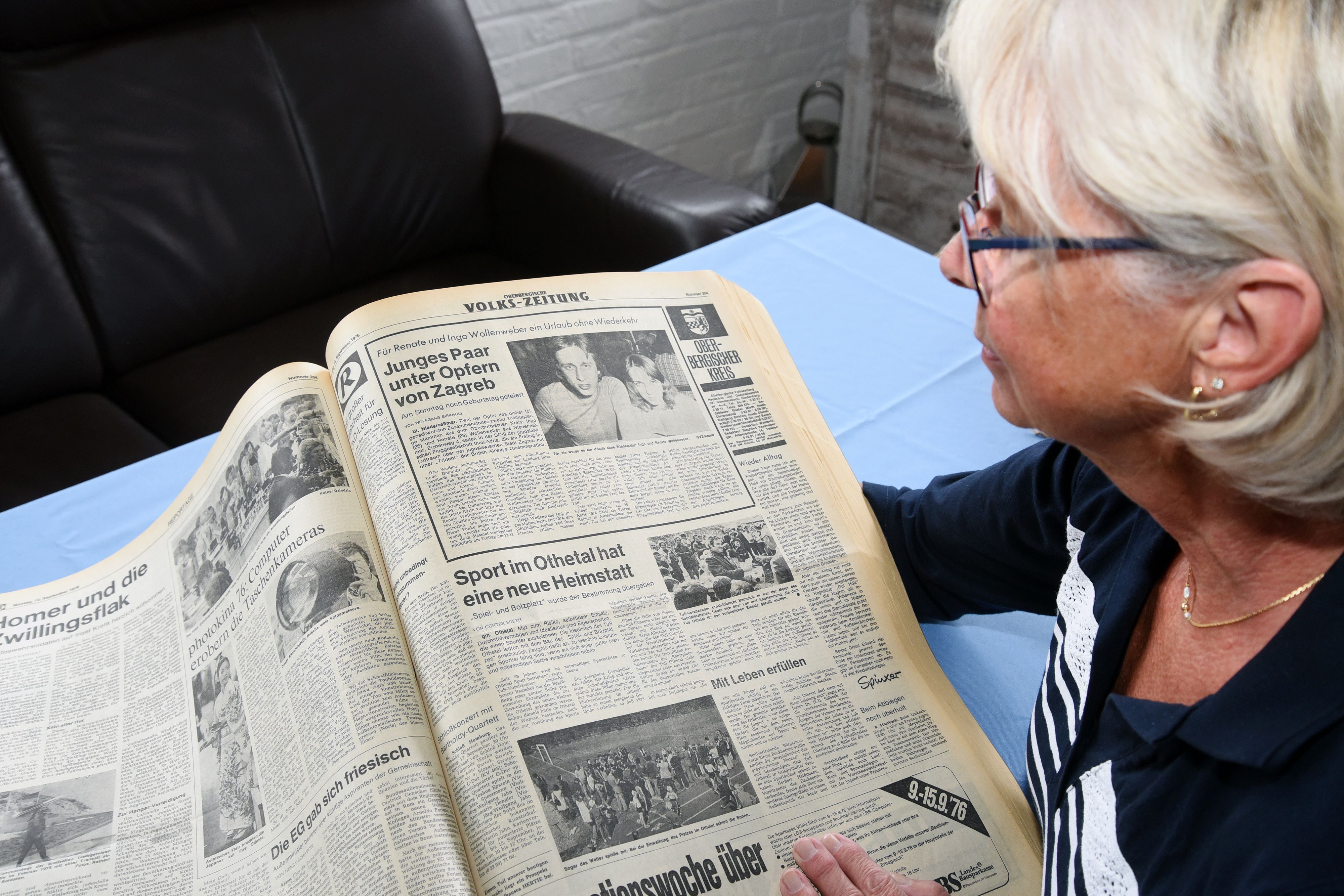 Eine Frau schaut auf einen alten Zeitungsartikel, in dem über einen Flugzeugabsturz vor 50 Jahren berichtet wird.
