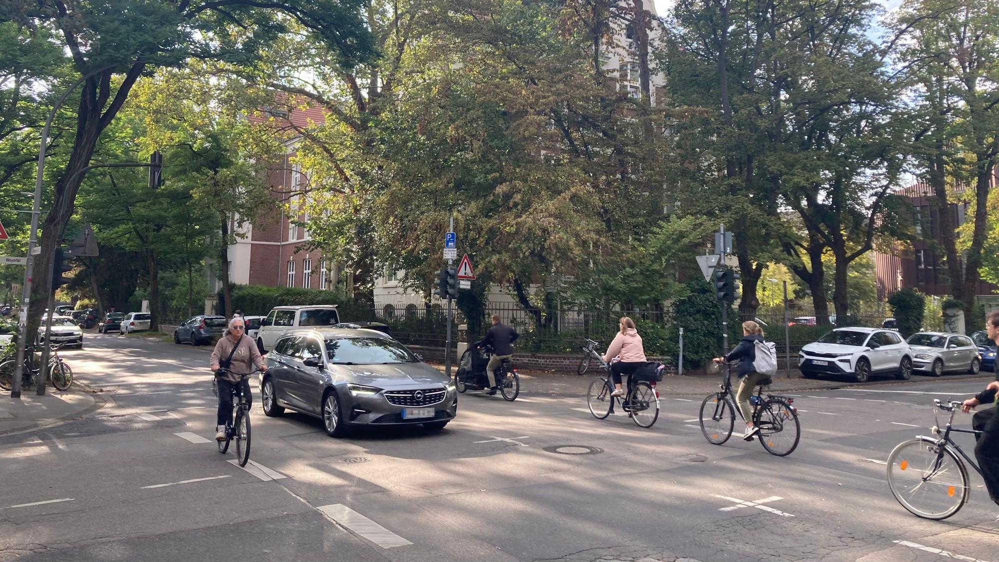Kerpener Straße/Ecke Weyertal in Köln-Lindenthal: Unter den grünen schattigen Bäumen fahren viele Kölnerinnen und Kölner zur Arbeit oder zur Universität. Wenn die Semesterferien vorbei sind, ist die Straße noch deutlich mehr befahren.