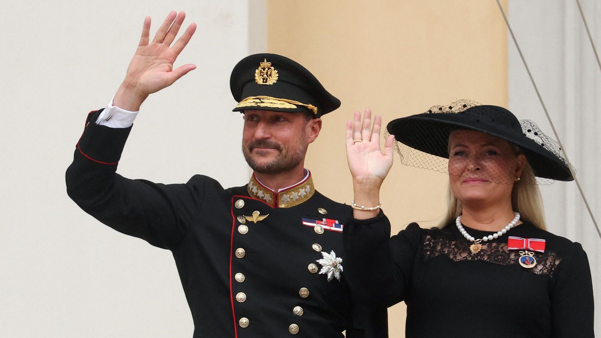 König Haakon und Königin Mette-Marit winken nach der Beisetzung von König Harald vom Palastbalkon.