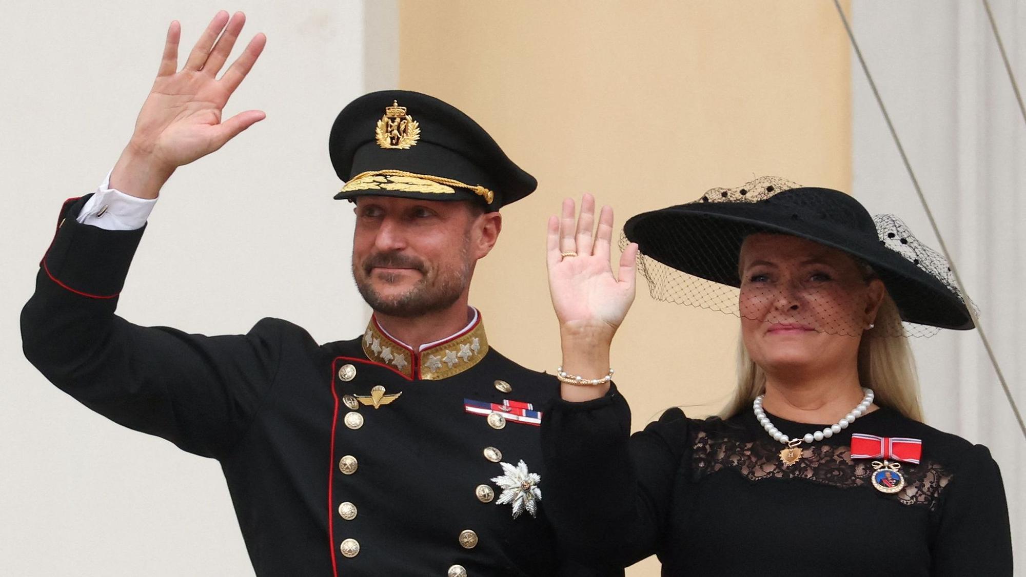 König Haakon und Königin Mette-Marit winken auf dem Palastbalkon.