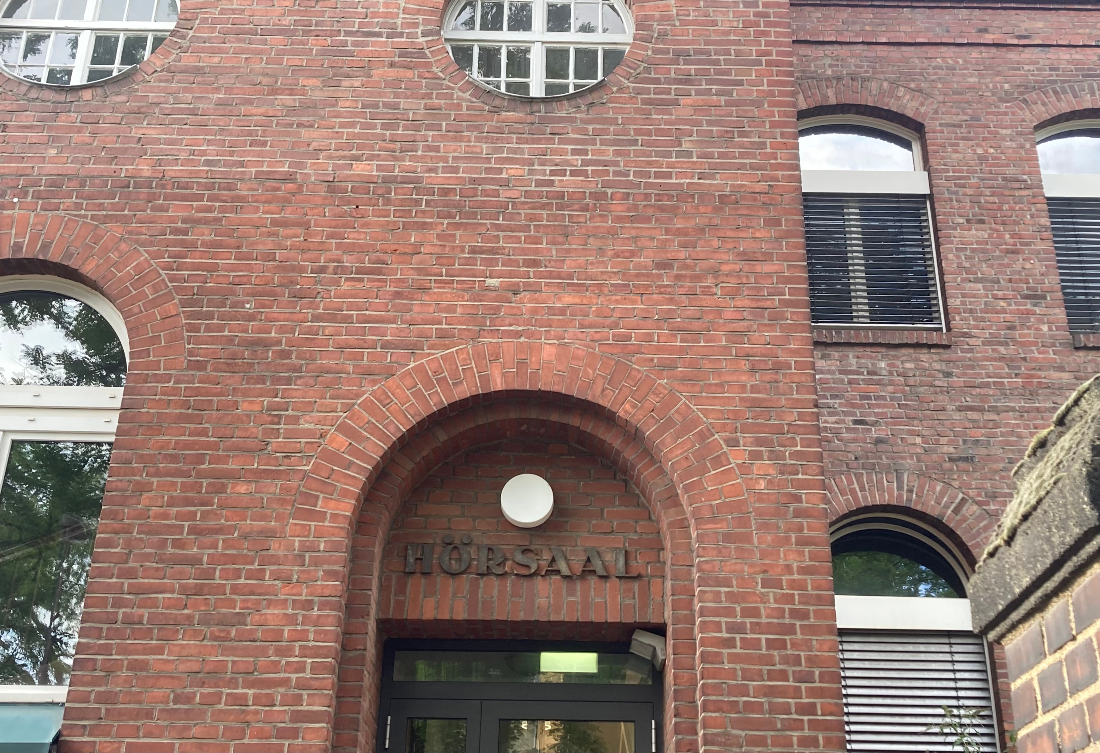 Im Gebäude der Zahnklinik befindet sich auch ein Hörsaal, der Schriftzug fügt sich harmonisch in die alte Backsteinarchitektur ein.