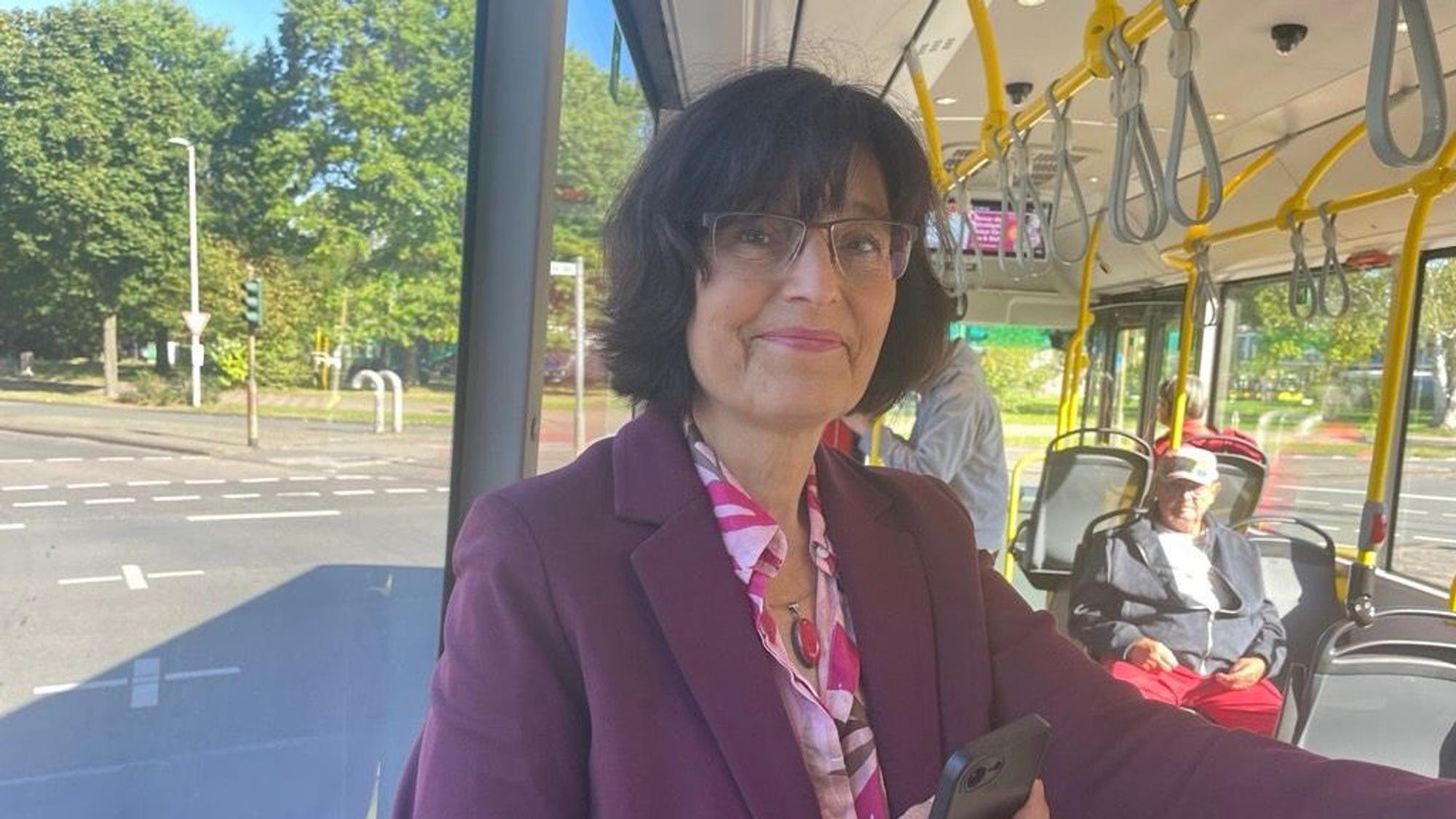 Die Redaktion hat Claudia Walther, Co-Vorsitzende der Kölner SPD, zufällig an der Bushaltestelle getroffen. Sie steht im Bus und lächelt in die Kamera.