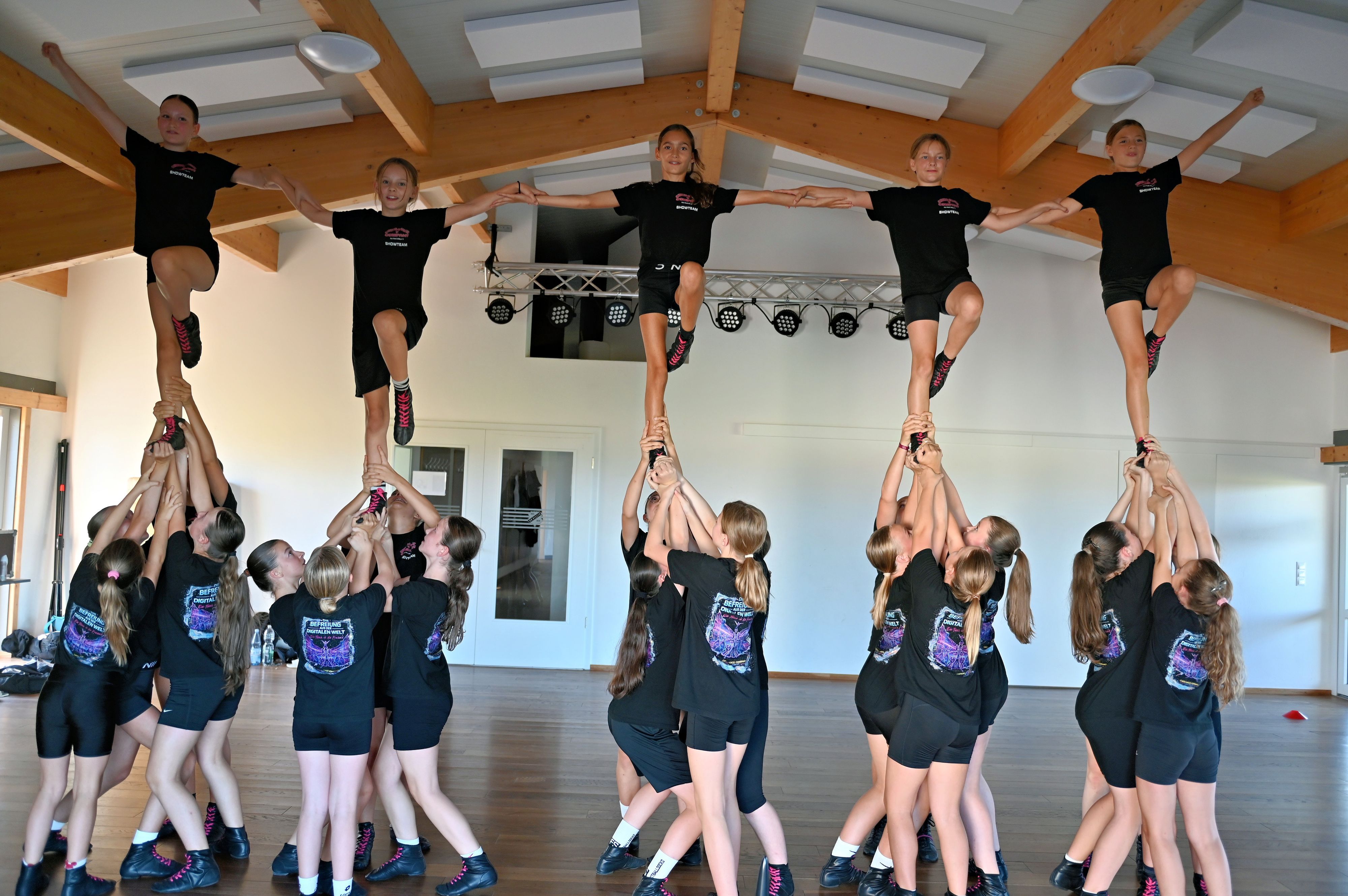 Fünf Tänzerinnen der Cheer-Dance-Company werden von vielen anderen Tänzerinnen in die Luft gehoben.