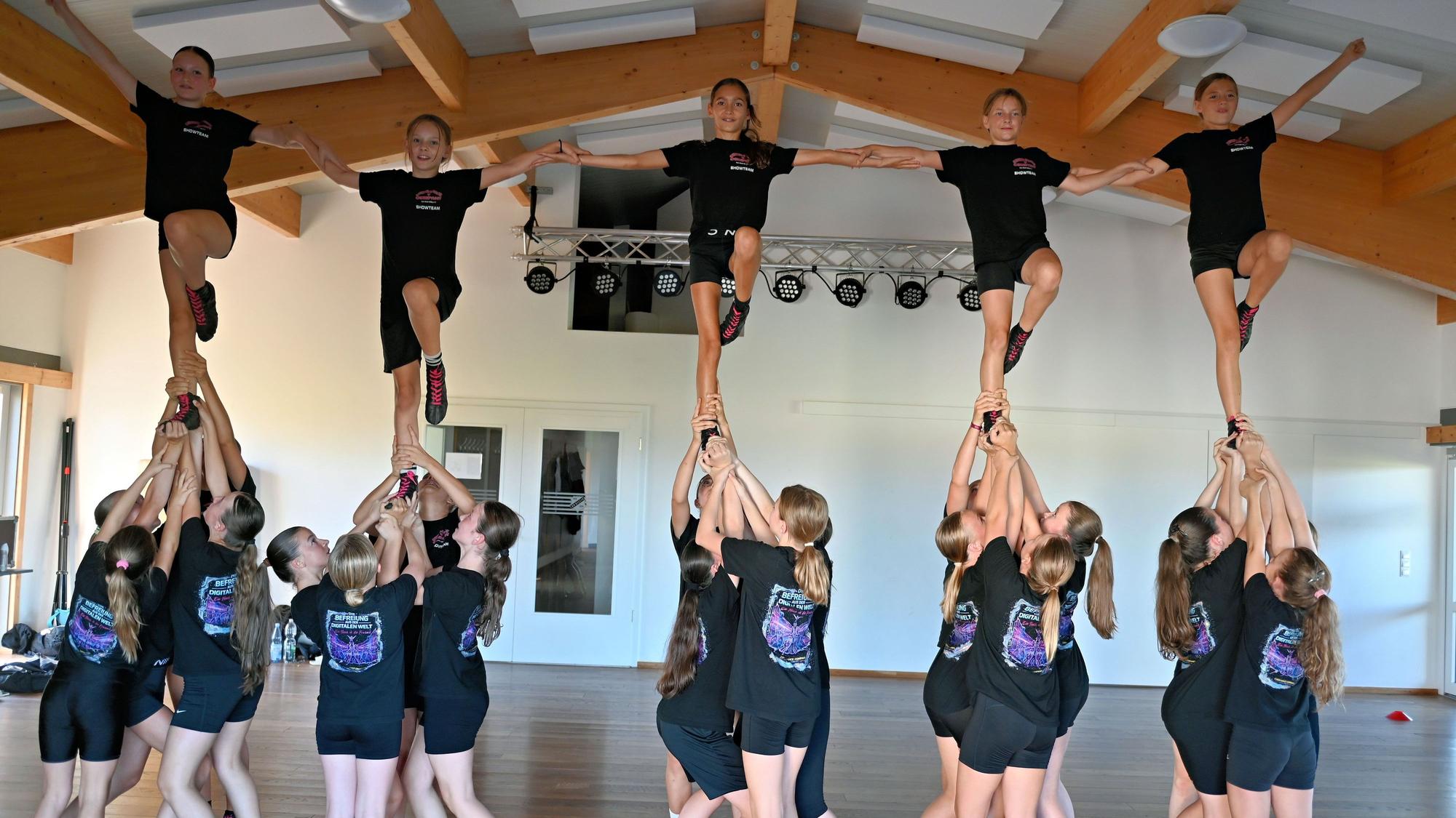 Fünf Tänzerinnen der Cheer-Dance-Company werden von vielen anderen Tänzerinnen in die Luft gehoben.