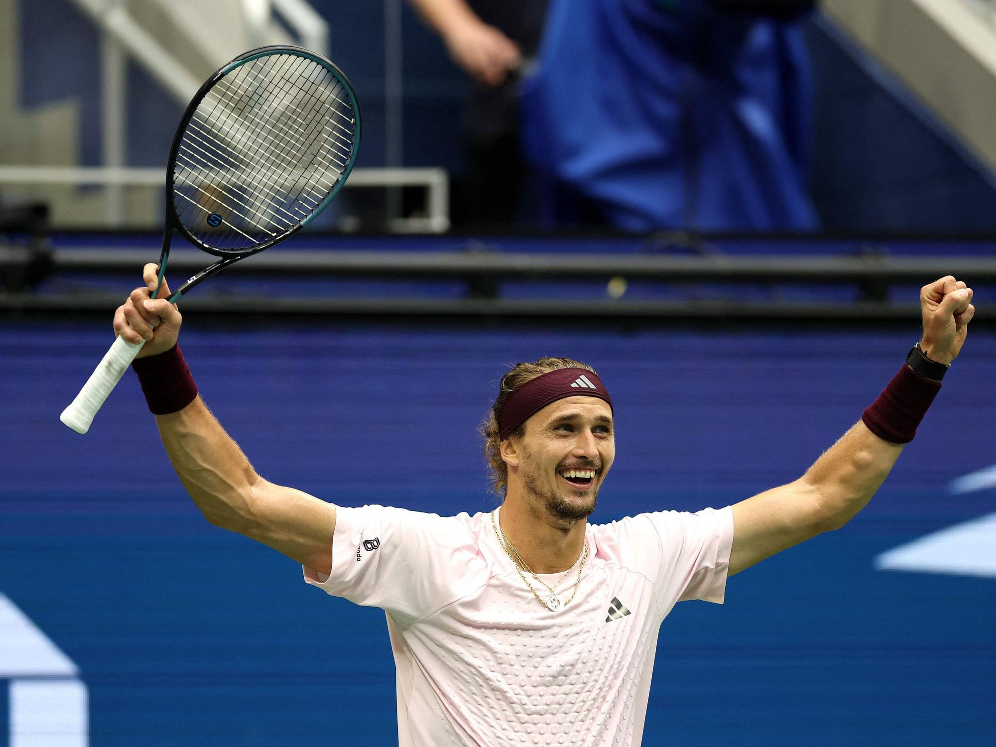 Alexander Zverev jubelt und streckt die Arme nach oben.