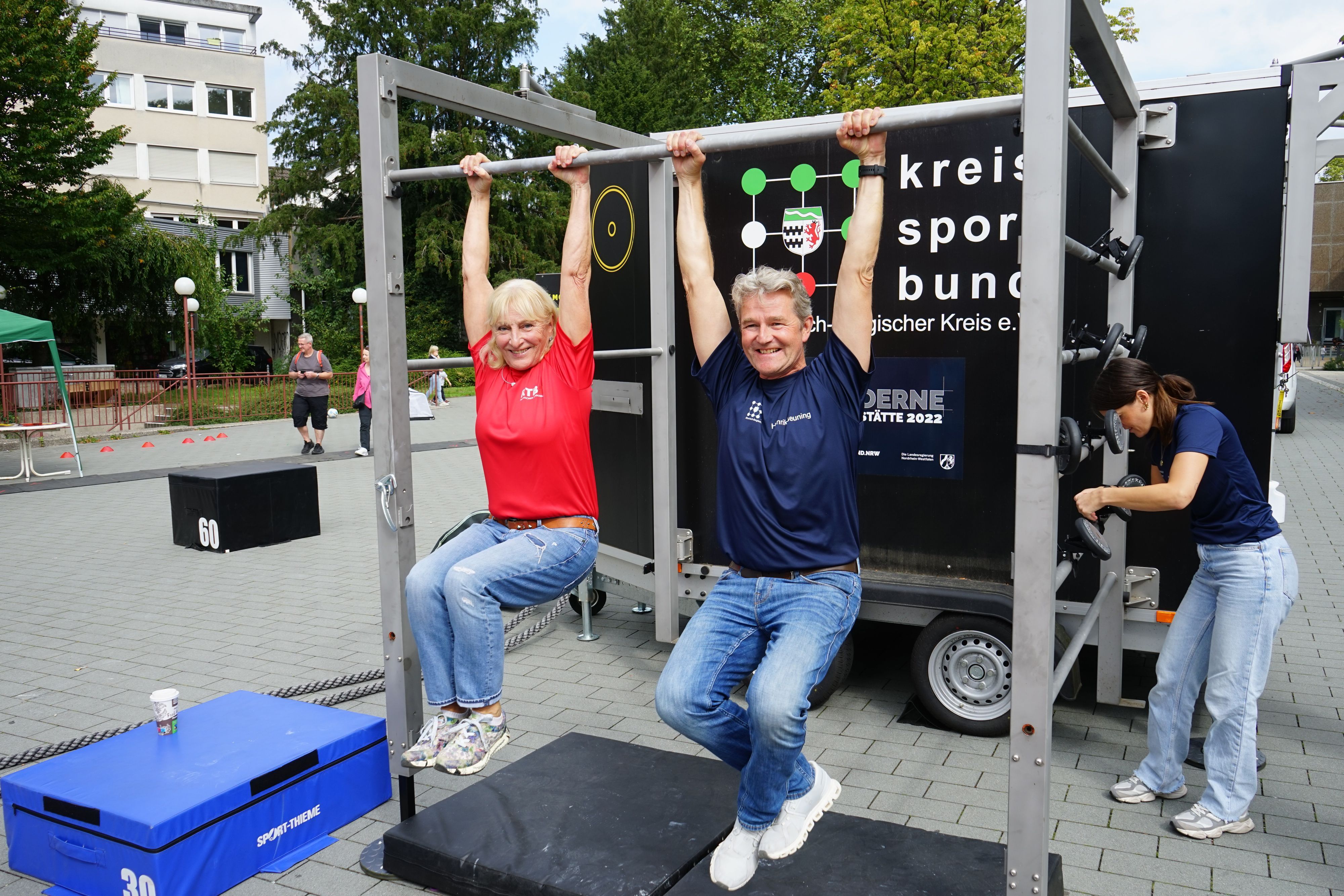 Rheinischer Turnerbund-Präsidentin Ulla Koch und Kreissportbund-Geschäftsführer Hendrik Beuning, hängen an einer  Stange.