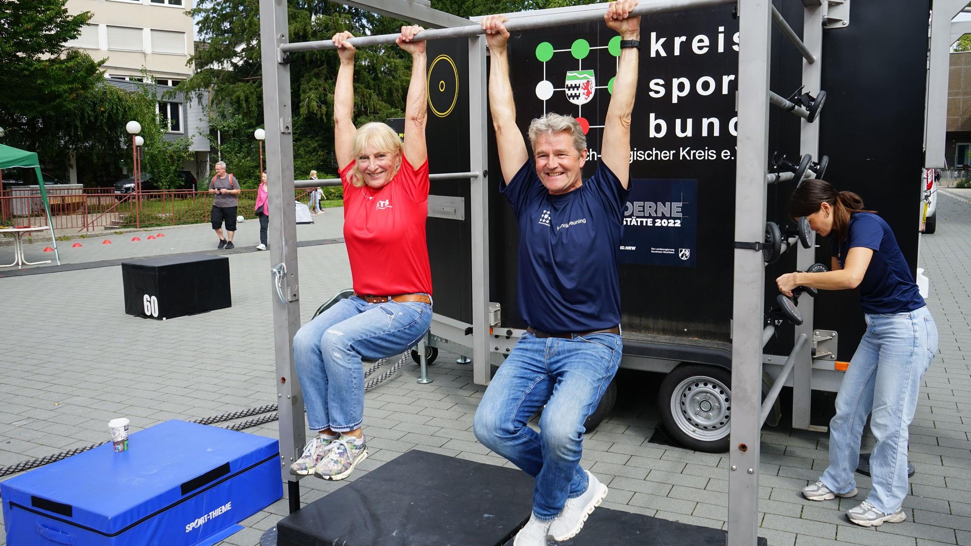 Rheinischer Turnerbund-Präsidentin Ulla Koch und Kreissportbund-Geschäftsführer Hendrik Beuning, hängen an einer Stange.