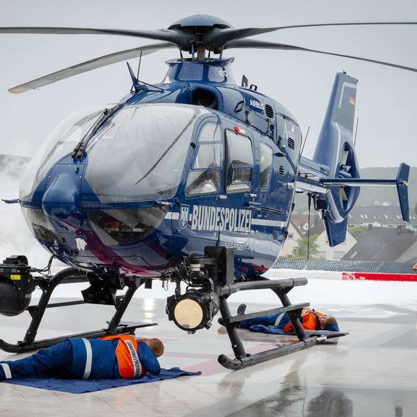 Im Rahmen einer Übung steht ein Helikopter der Bundespolizei auf dem Hubschrauberlandeplatz des Kreiskrankenhaus Mechernich. Zwei Jugendfeuerwehrleute liegen darunter und mimen Verletzte, mit Pyrotechnik wird Rauch erzeugt.