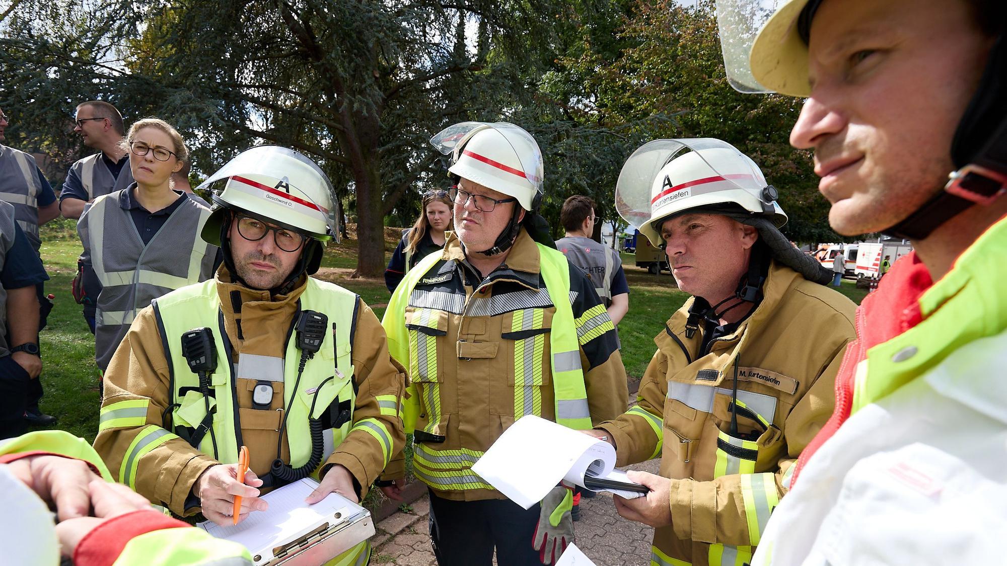 Vier Feuerwehrleute stehen nebeneinander.