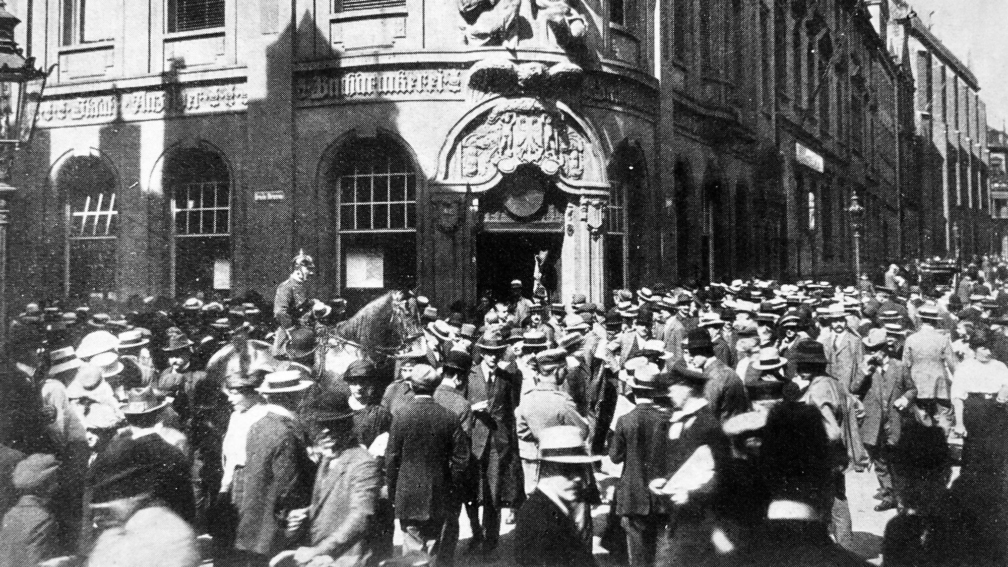 Menschen warten am 1. August 1914 vor dem Gebäude der „Kölnischen Zeitung“ und des „Stadt-Anzeigers“ auf Nachrichten zum Kriegsausbruch.