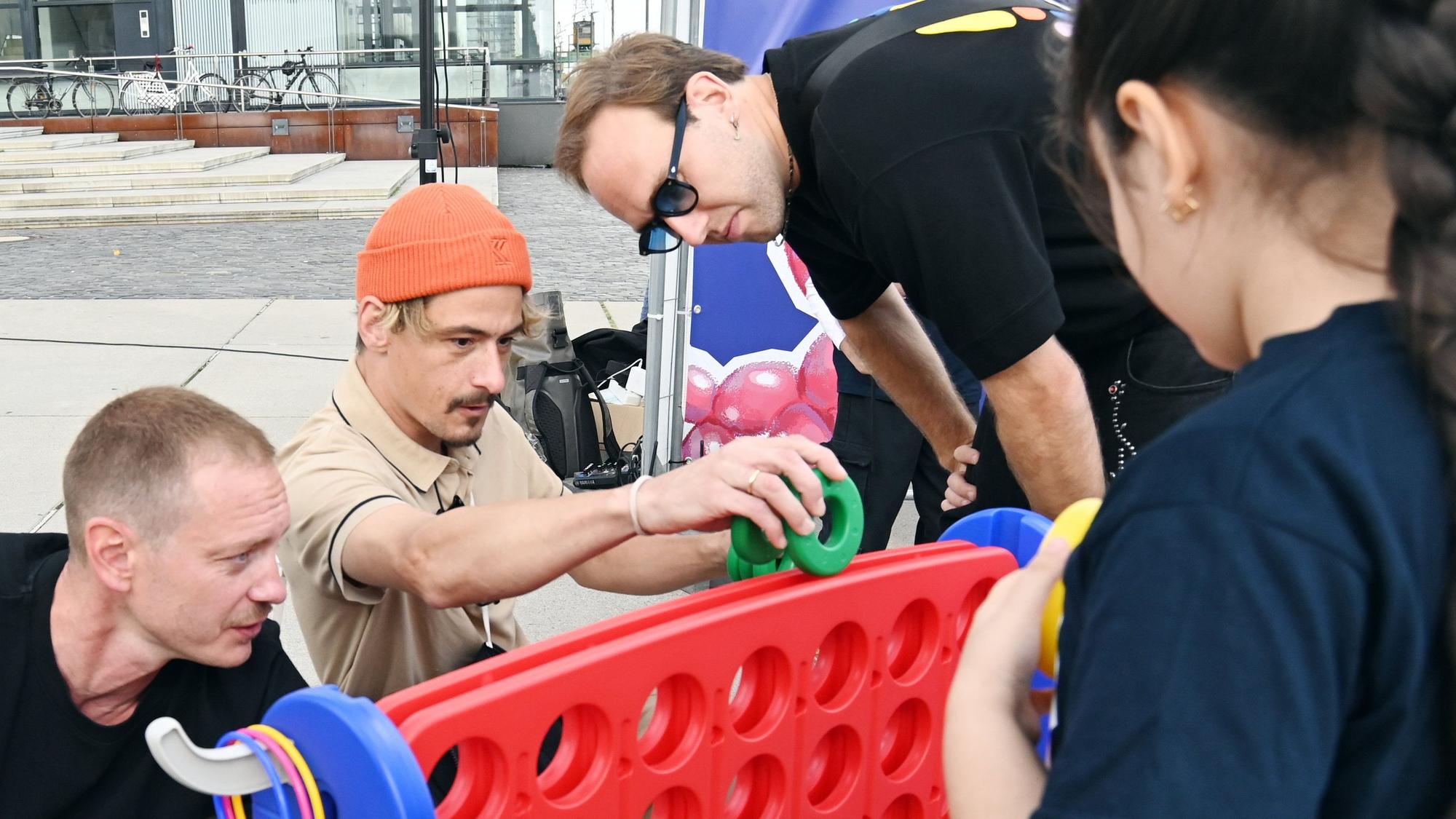 Kevin Wittwer (links) und Yannick Richter von Cat Ballou sind Botschafter des Weltkindertags, sie spielen mit Kindern des Linoclub-Kinderrats am Harry-Blum-Platz.
