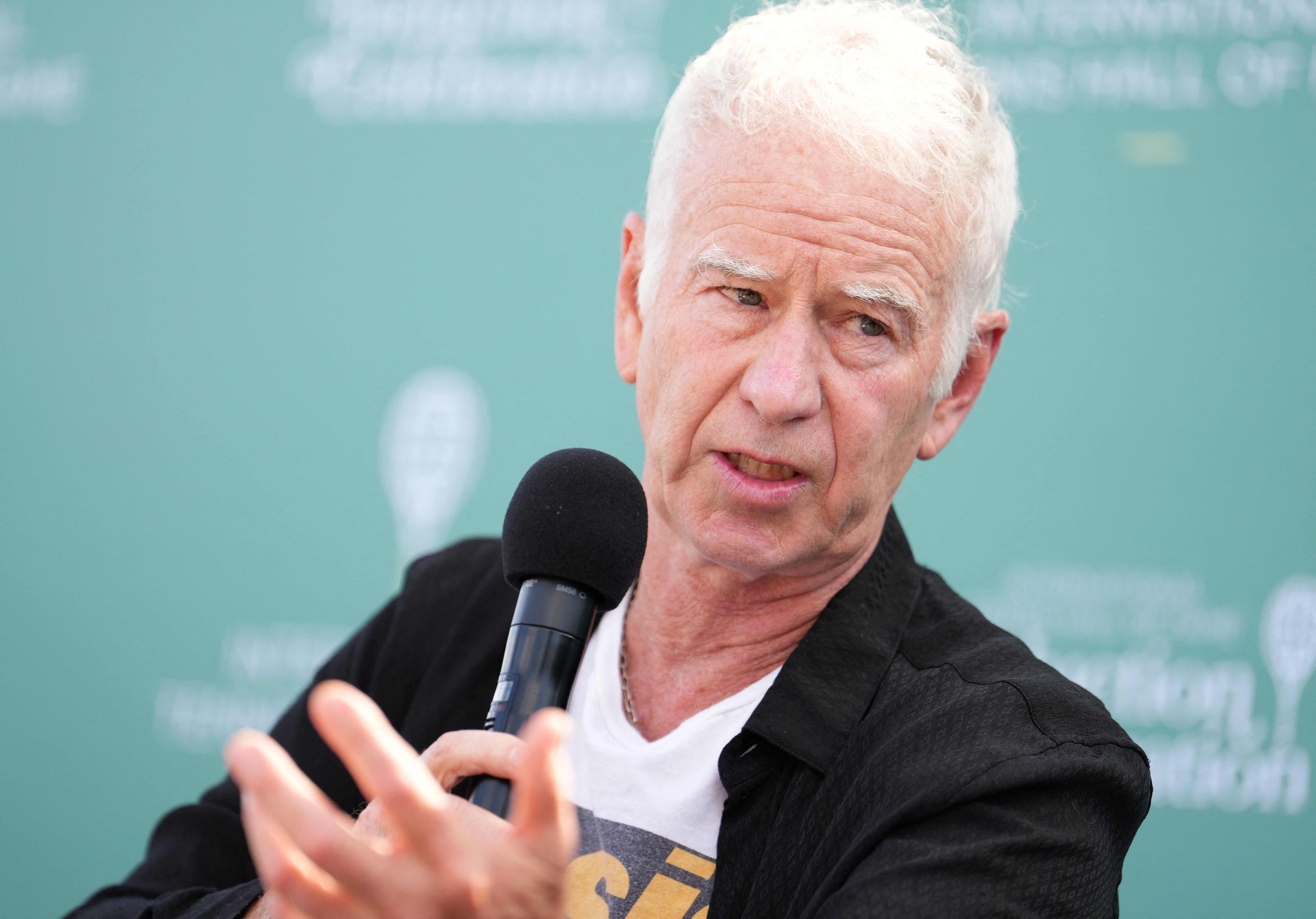 John McEnroe spricht in ein Mikrofon.