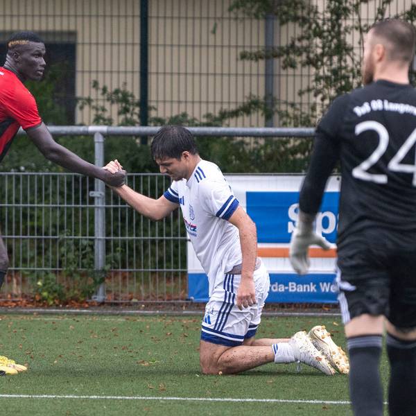 Das Bild zeigt den obgenannten Fußballer, der seinem Gegenspieler wieder auf die Beine hilft.