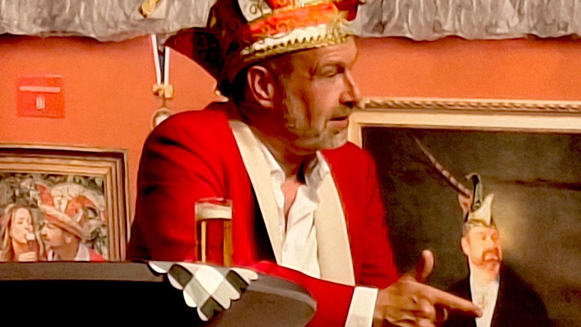 Volker Weininger sitzt im Ornat vor einem Bild, das ihn im Stil Rembrandts gemalt zeigt.