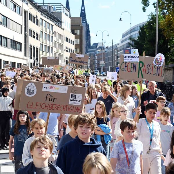 Schülerinnen und Schüler des Hansa-Gymnasiums halten bei einer Demo in der Kölner Innenstadt Schilder hoch.
