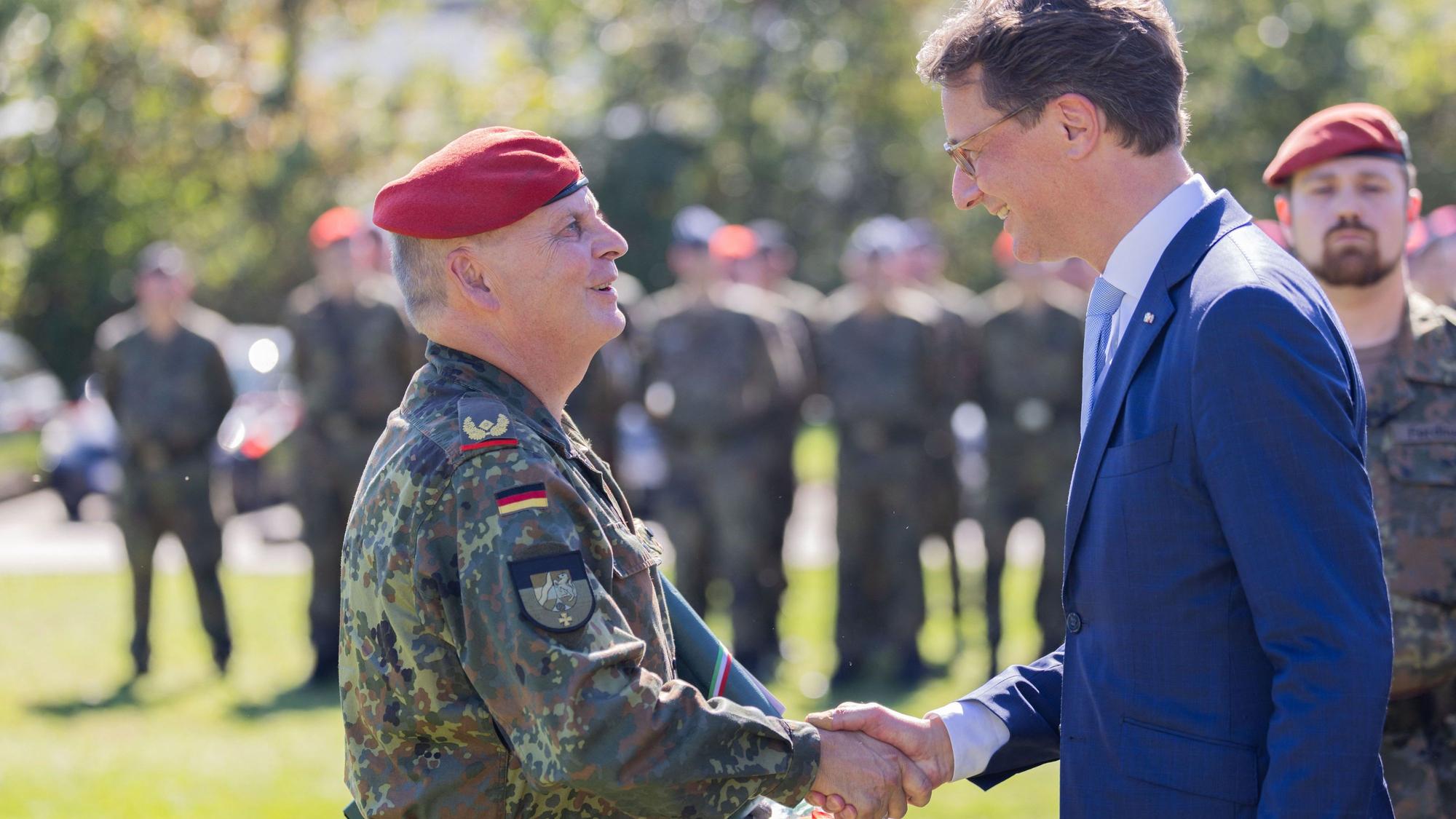 Hendrik Wüst (CDU, r), Ministerpräsident von Nordrhein-Westfalen, nimmt neben Brigadegeneral Hans-Dieter Müller an der feierlichen Kommandoübergabe beim Landeskommando Nordrhein-Westfalen teil.