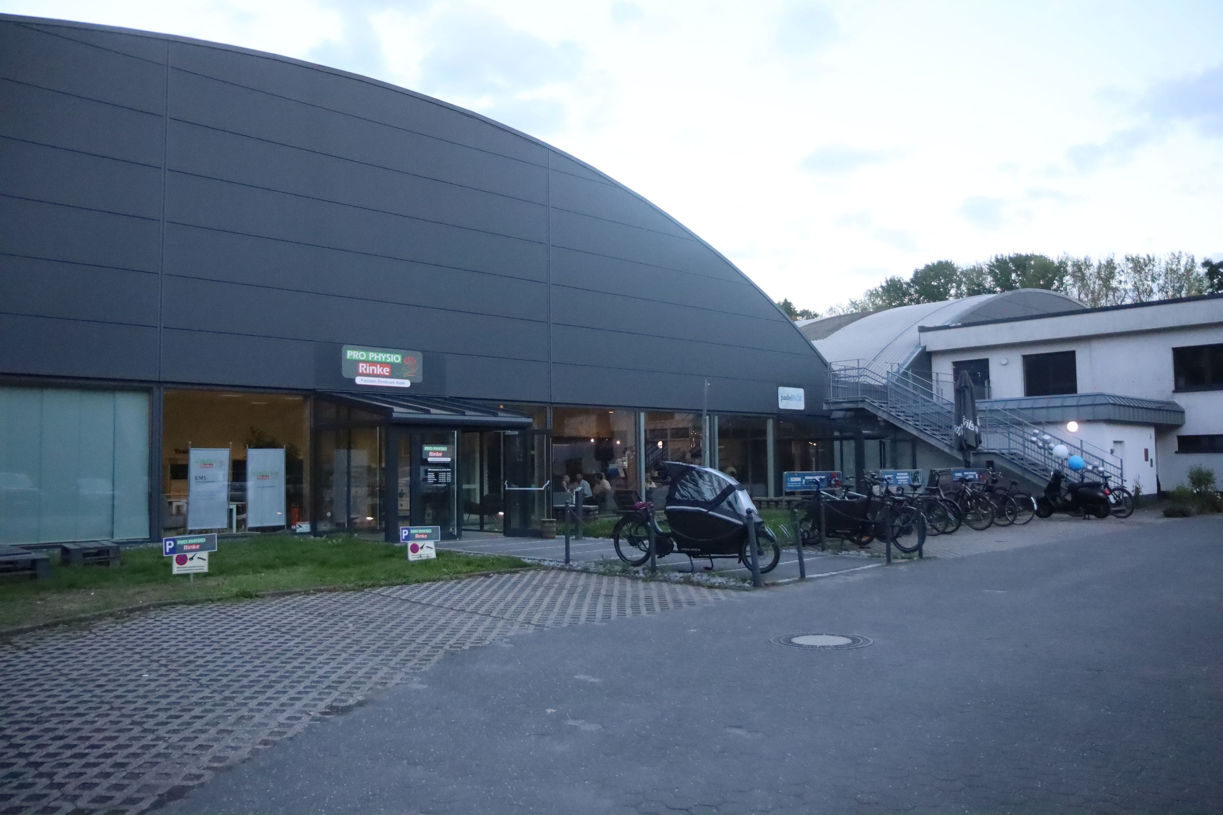Eine Halle mit einem Anbau ist zu sehen.