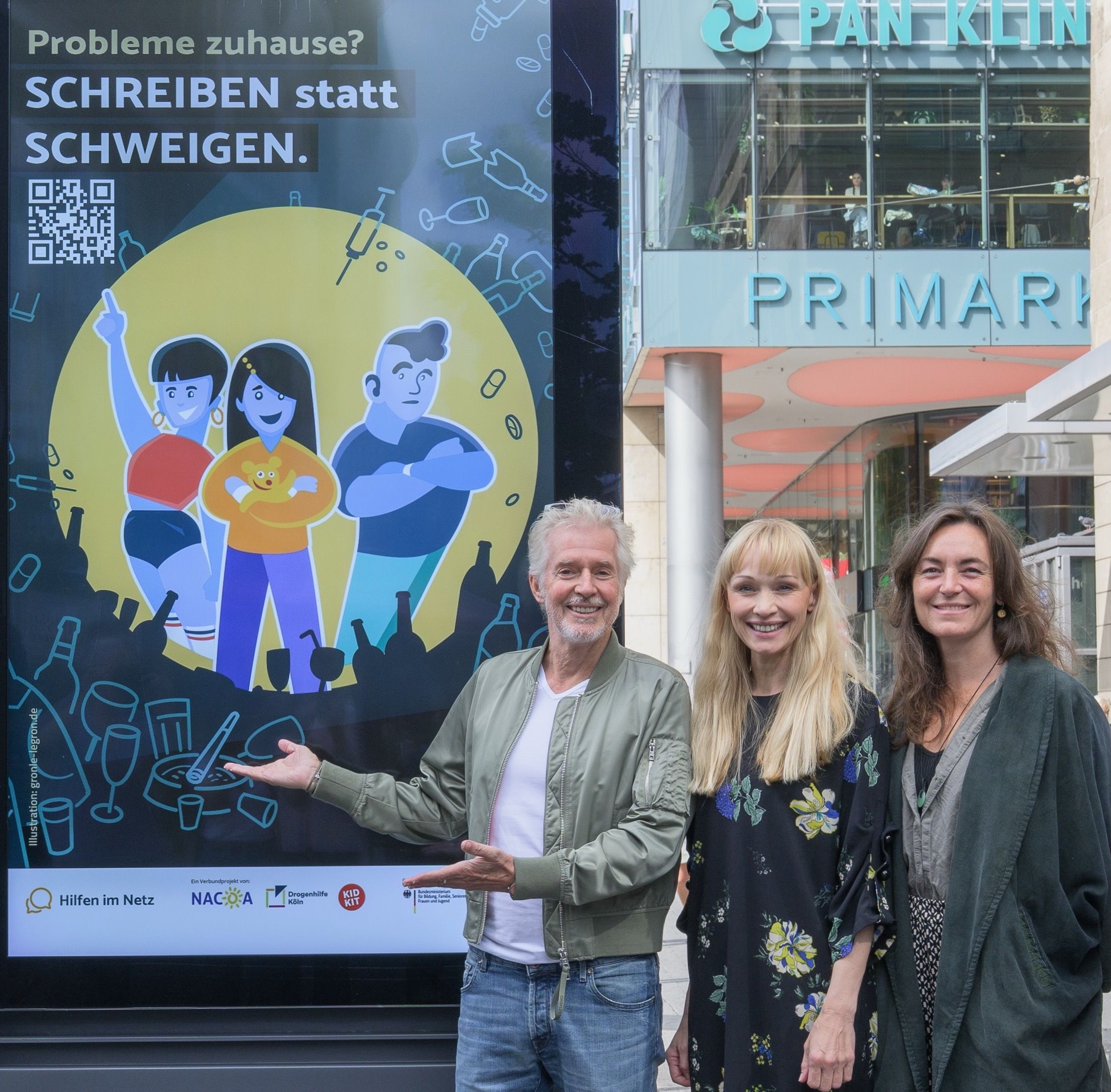 Bestsellerautor Frank Schätzing, Anna Buning (Leiterin der Onlineberatung Kidkit) und Tanja Ruppert, Sozialarbeiterin bei NACOA Deutschland e.V., präsentieren die neue Plakataktion am Kölner Neumarkt.