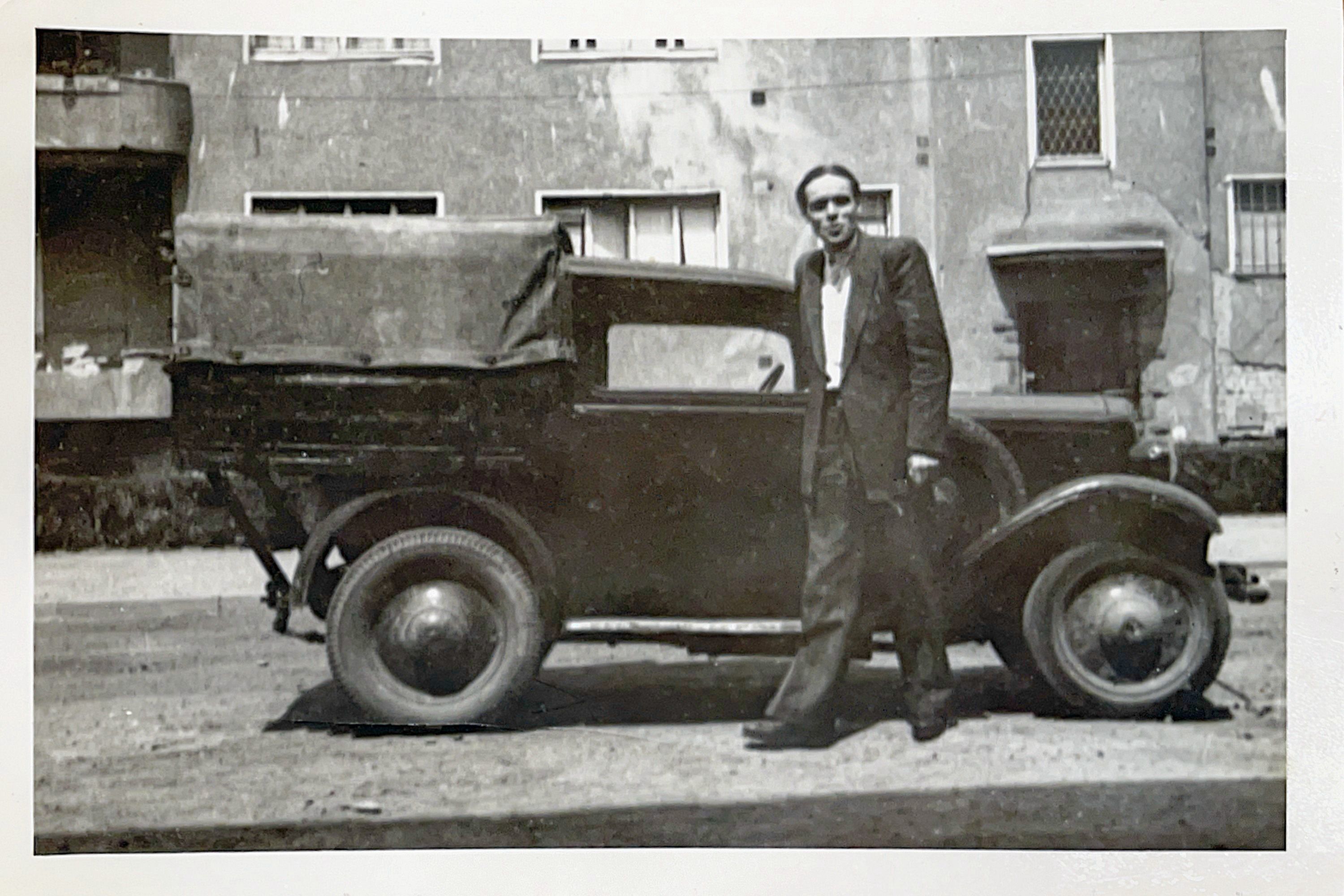 Auf einem Schwarz-Weiß-Bild ist Helmut Hinz vor einem alten Auto zu sehen. Er gründete 1946  einen Elektrobetrieb.