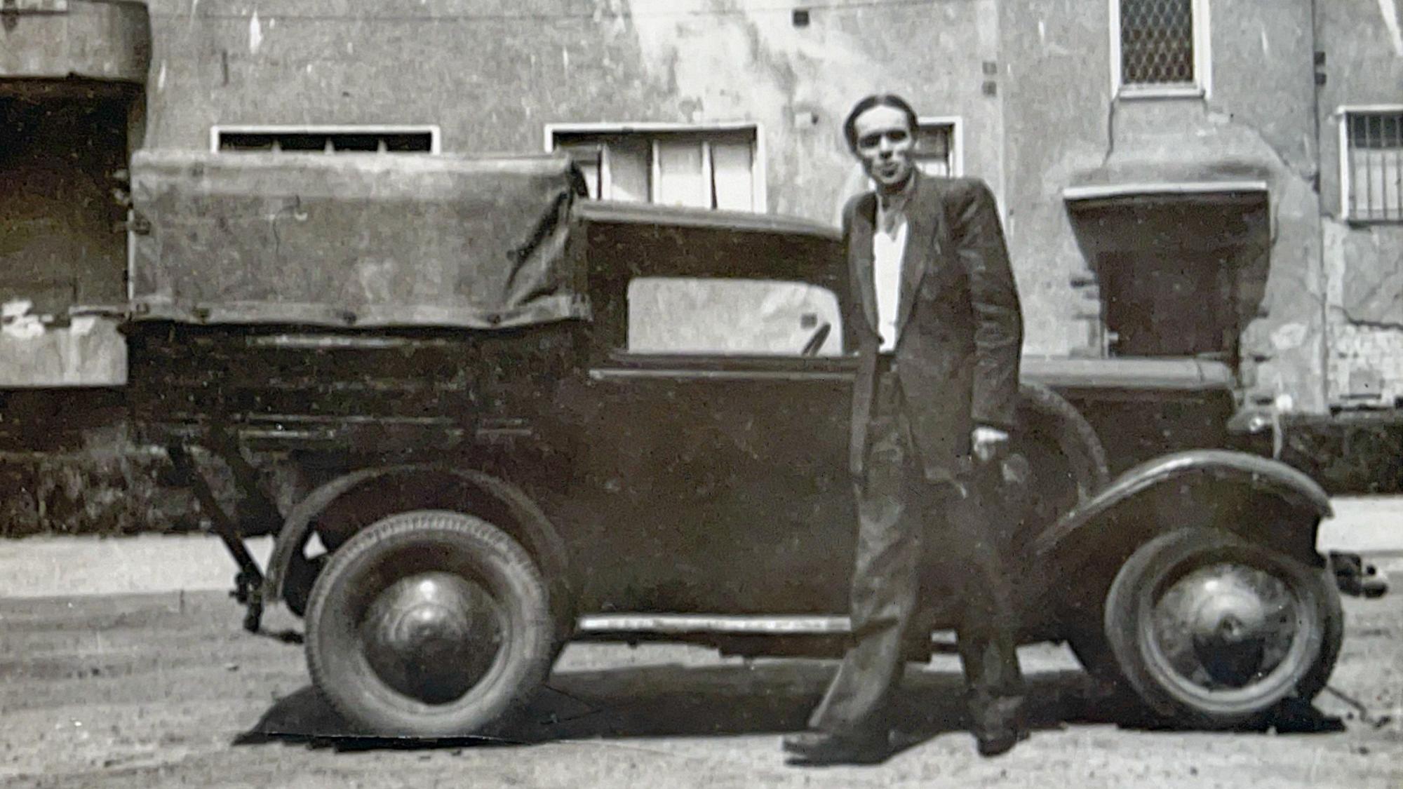 Auf einem Schwarz-Weiß-Bild ist Helmut Hinz vor einem alten Auto zu sehen. Er gründete 1946 einen Elektrobetrieb.