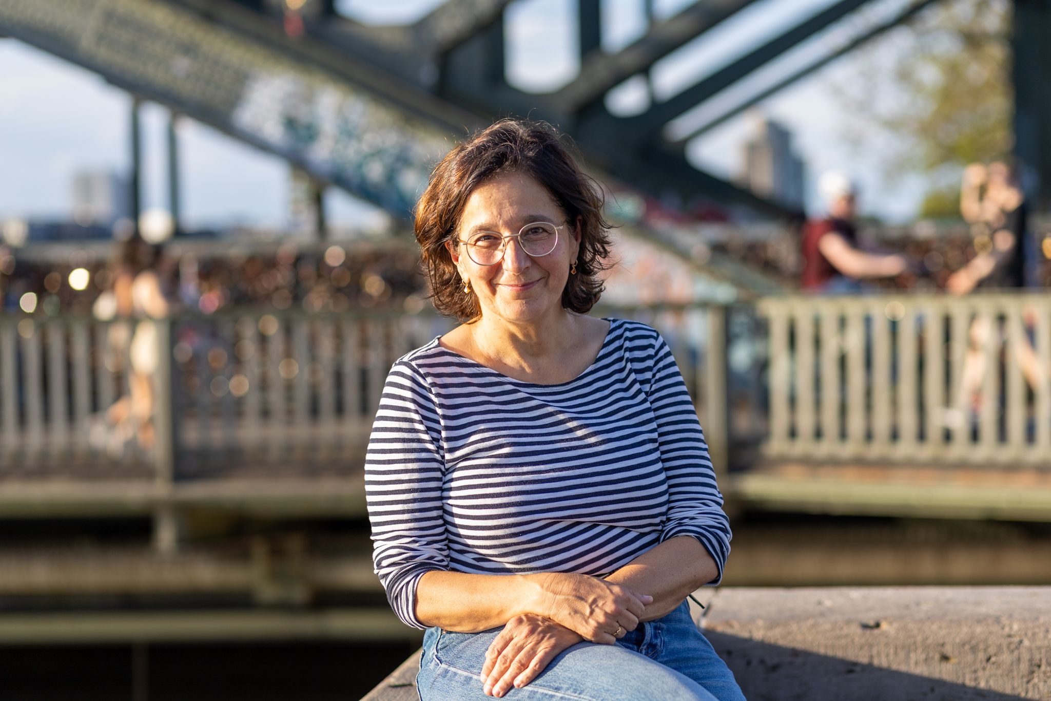 Eine Frau im gestreiften Oberteil lächelt in die Kamera.