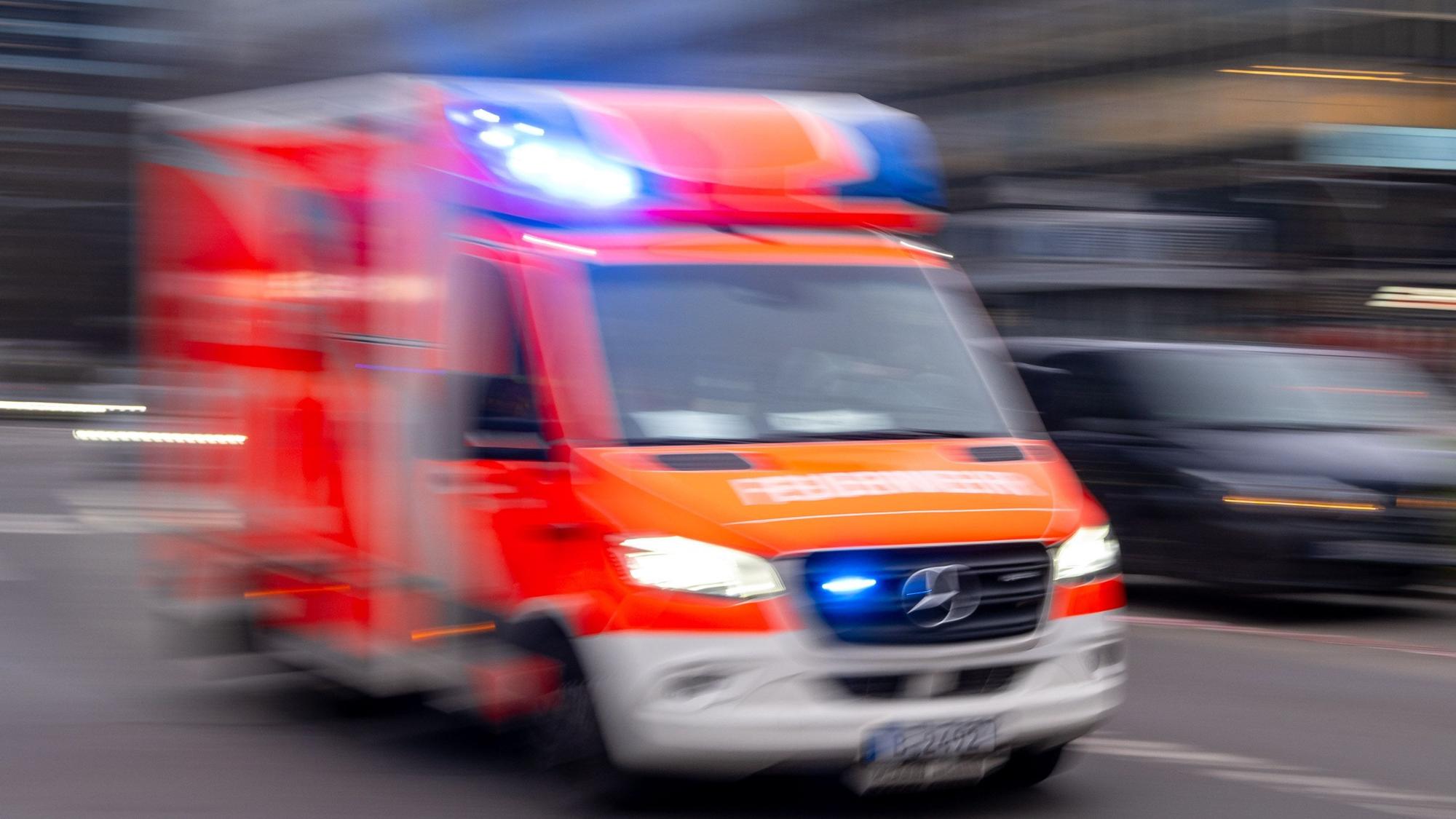 Ein Rettungswagen der Feuerwehr fährt mit Blaulicht zum Einsatz. (Symbolbild)