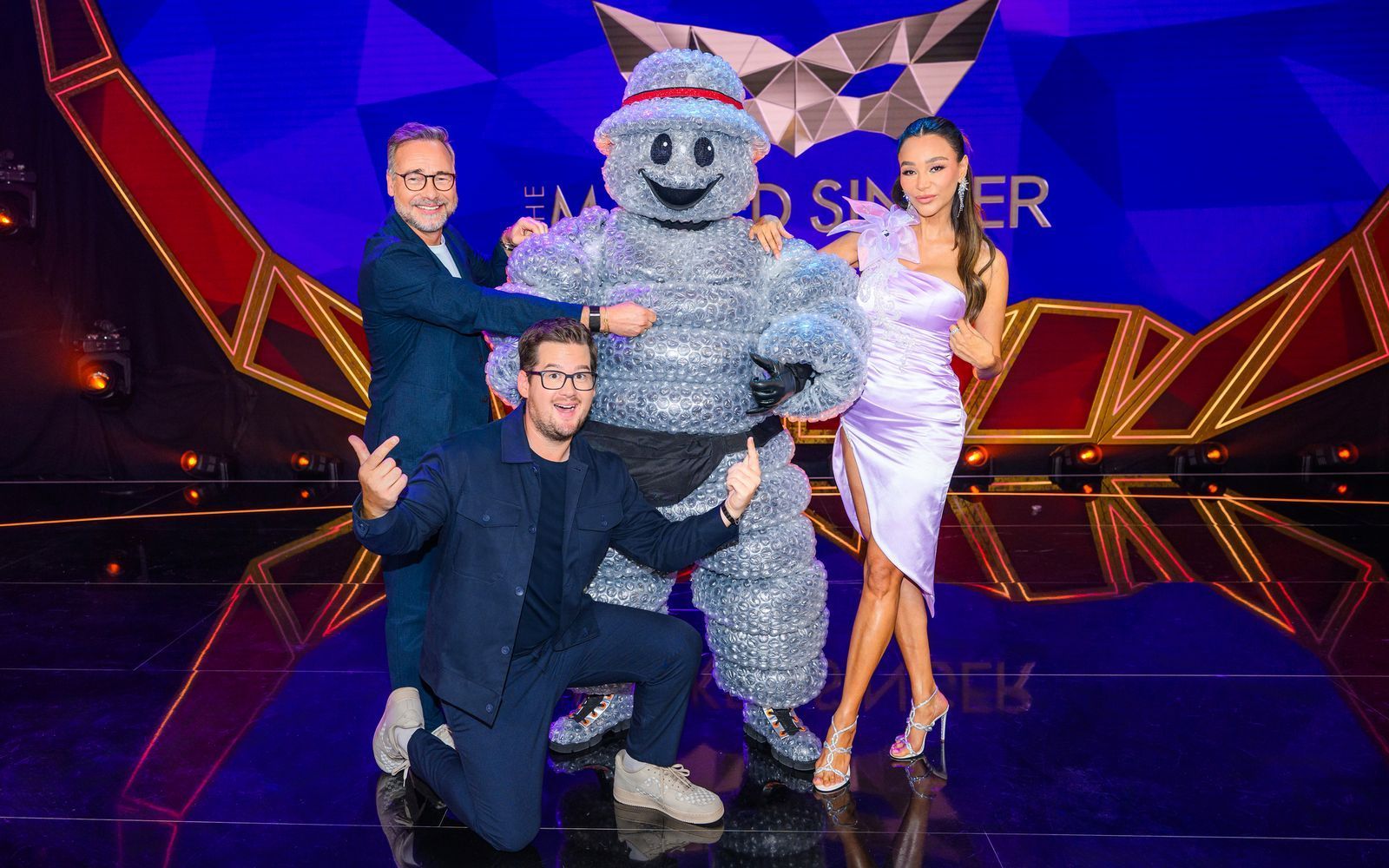 Chris Tall (vorne) und Verona Pooth freuen sich, eine weitere Staffel von „The Masked Singer“ als Rateteam zu begleiten.  (Bild: Joyn/Willi Weber)