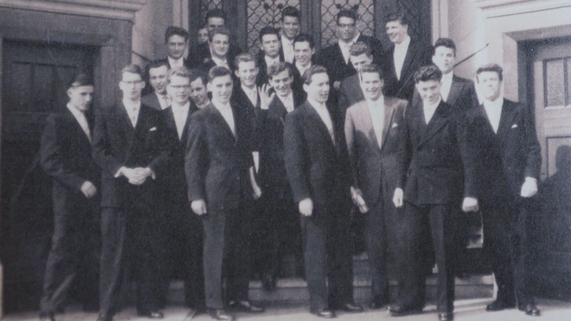 Die Abiturienten von 1958 stehen auf Treppenstufen, sie tragen dunkle Anzüge.