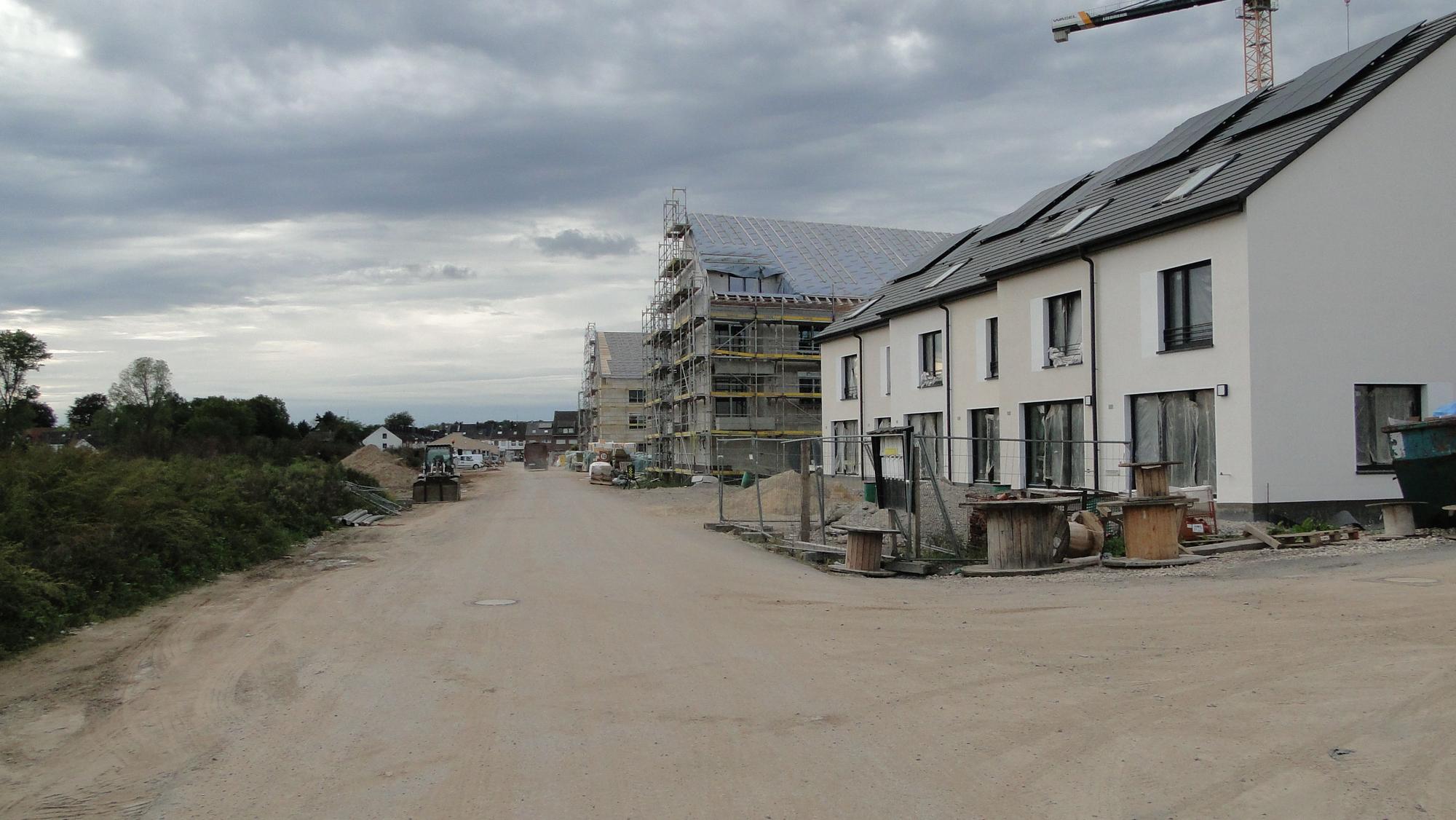 Ein Neubaugebiet mit Mehr- und Einfamilienhäusern im Rohbau.