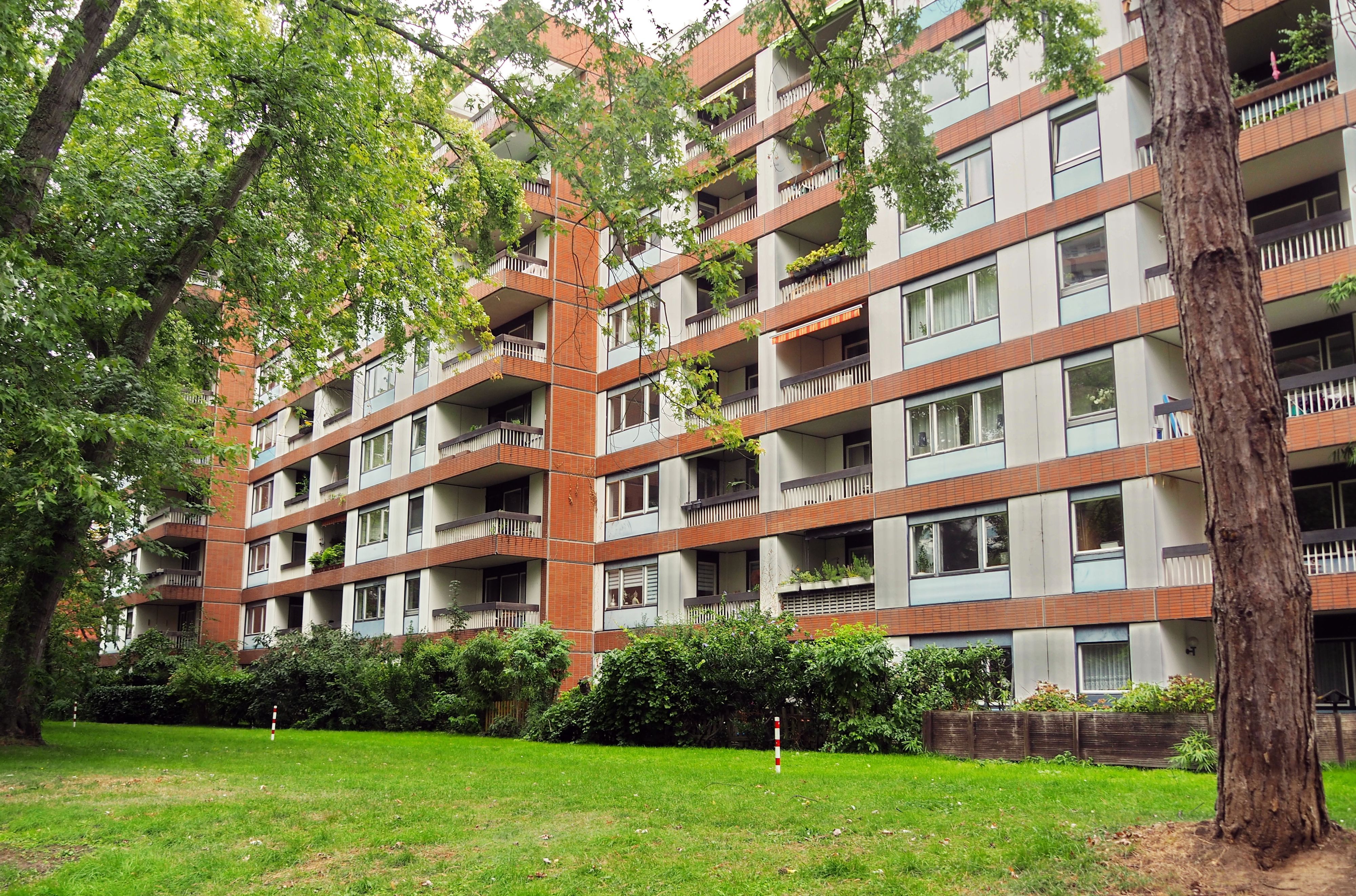 Mehrstöckige Wohnblocks stehen hinter einer Rasenfläche.