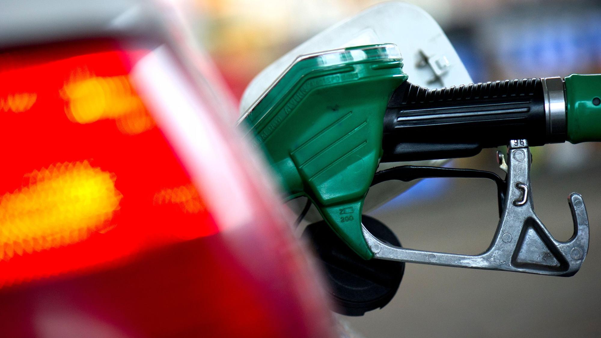 An einer Tankstelle steckt ein Zapfstutzen einer Zapfsäule im Tank eines Autos. (Archivbild)