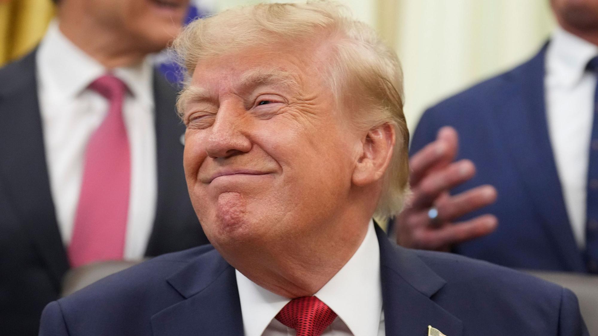 Donald Trump grinst bei einer Veranstaltung im Oval Office.