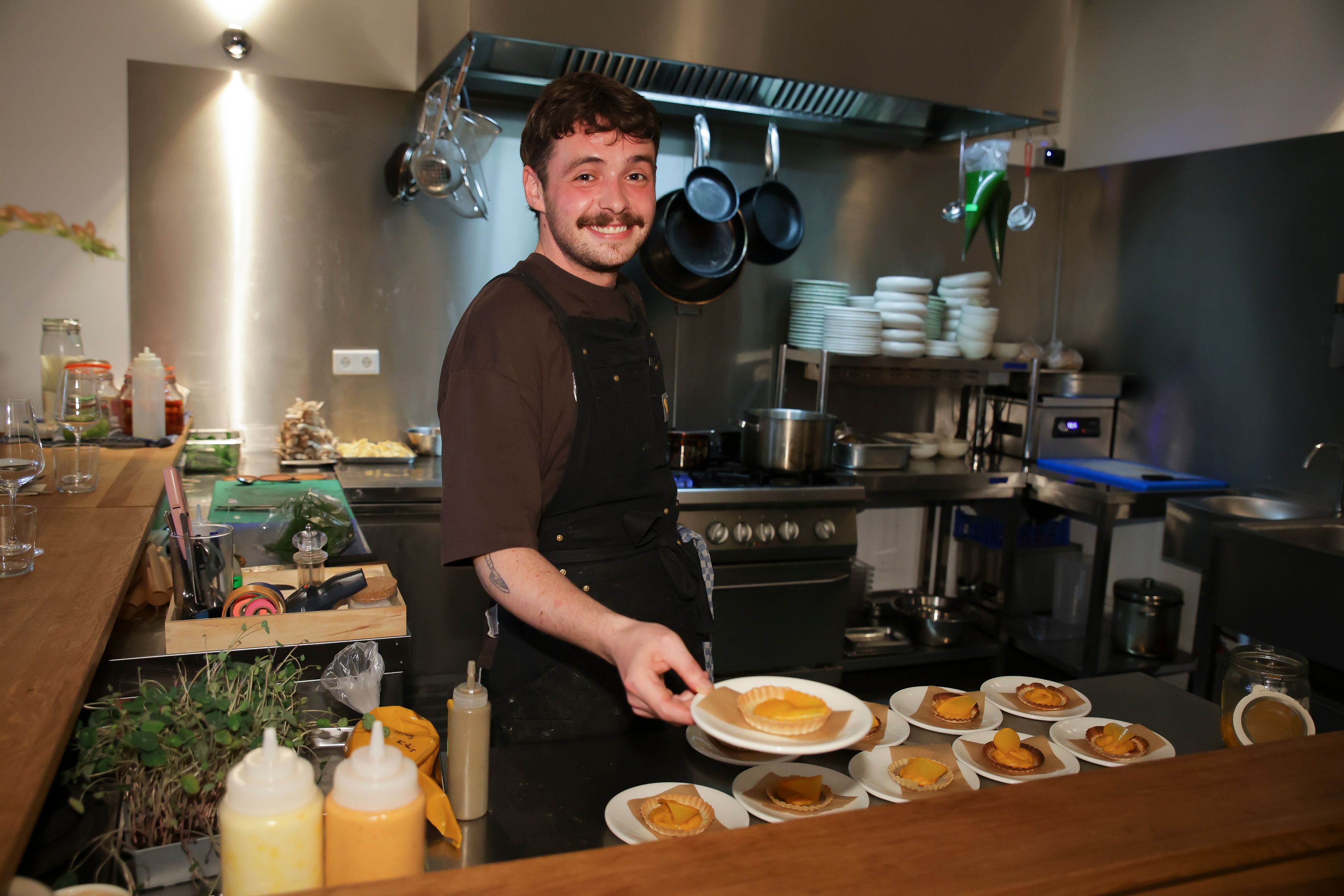 Sascha Bobb reicht Tartelettes über eine Theke.