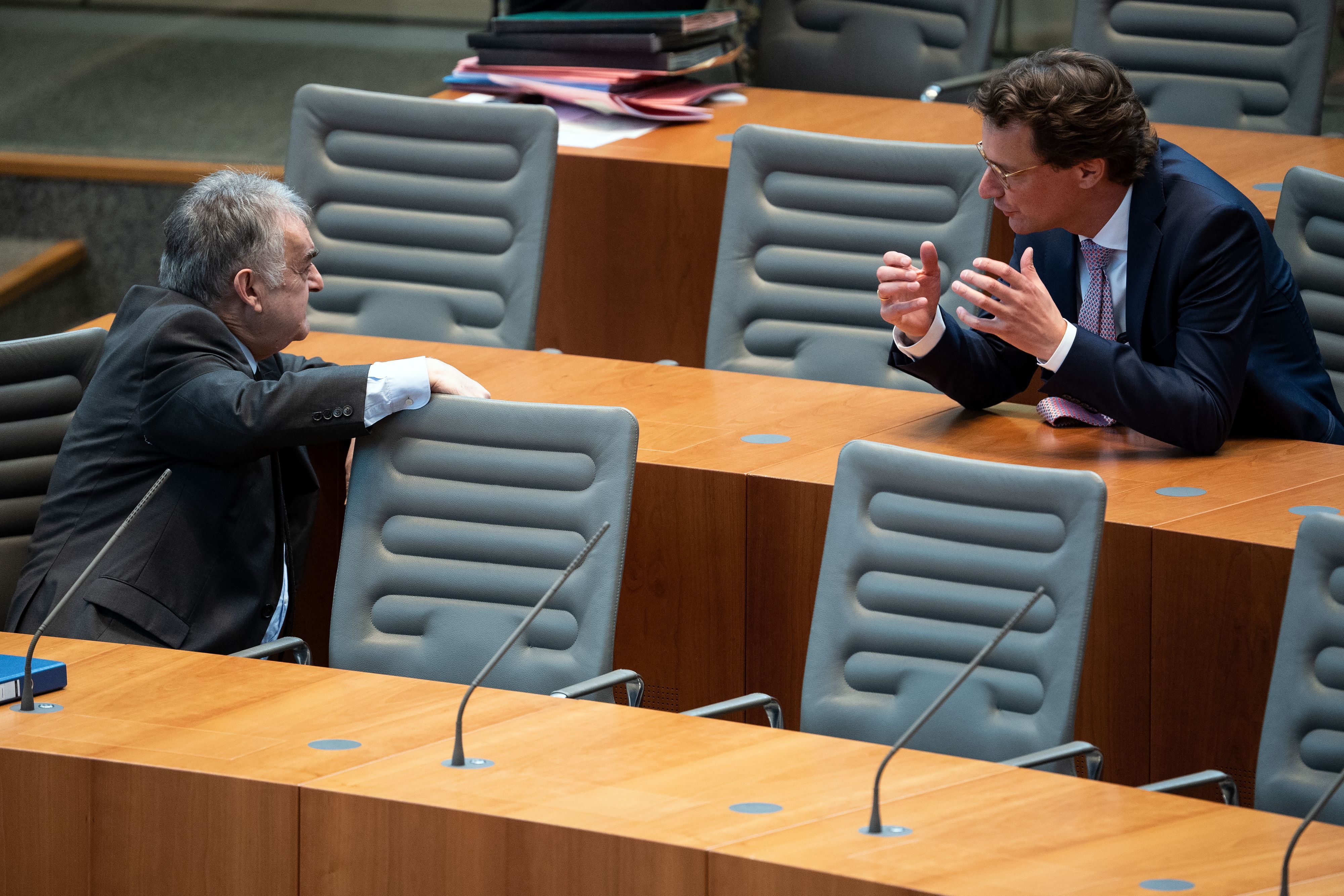 Herbert Reul (l), Innenminister von Nordrhein-Westfalen, und Hendrik Wüst unterhalten sich im Landtag.