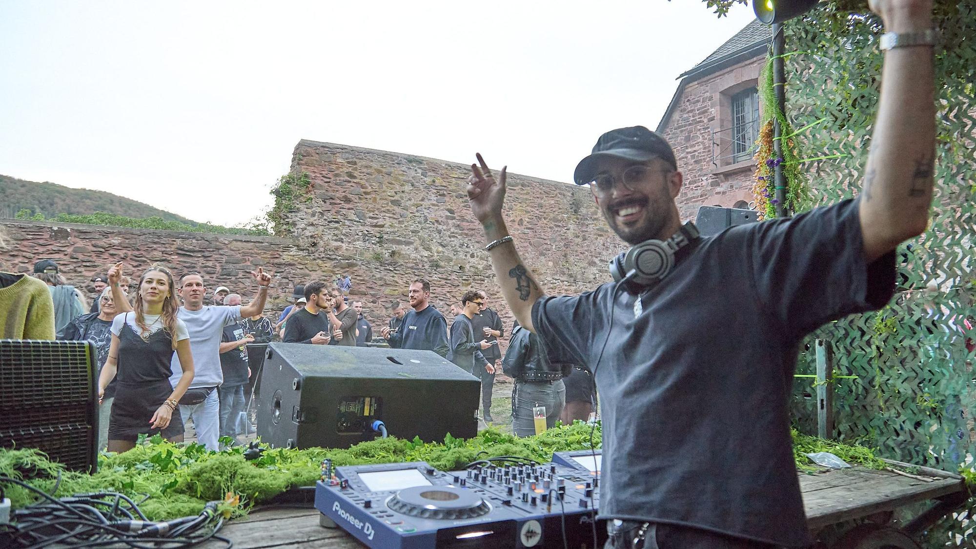 Das Bild zeigt den DJ, der mit erhobenen Armen in die Kamera schaut.