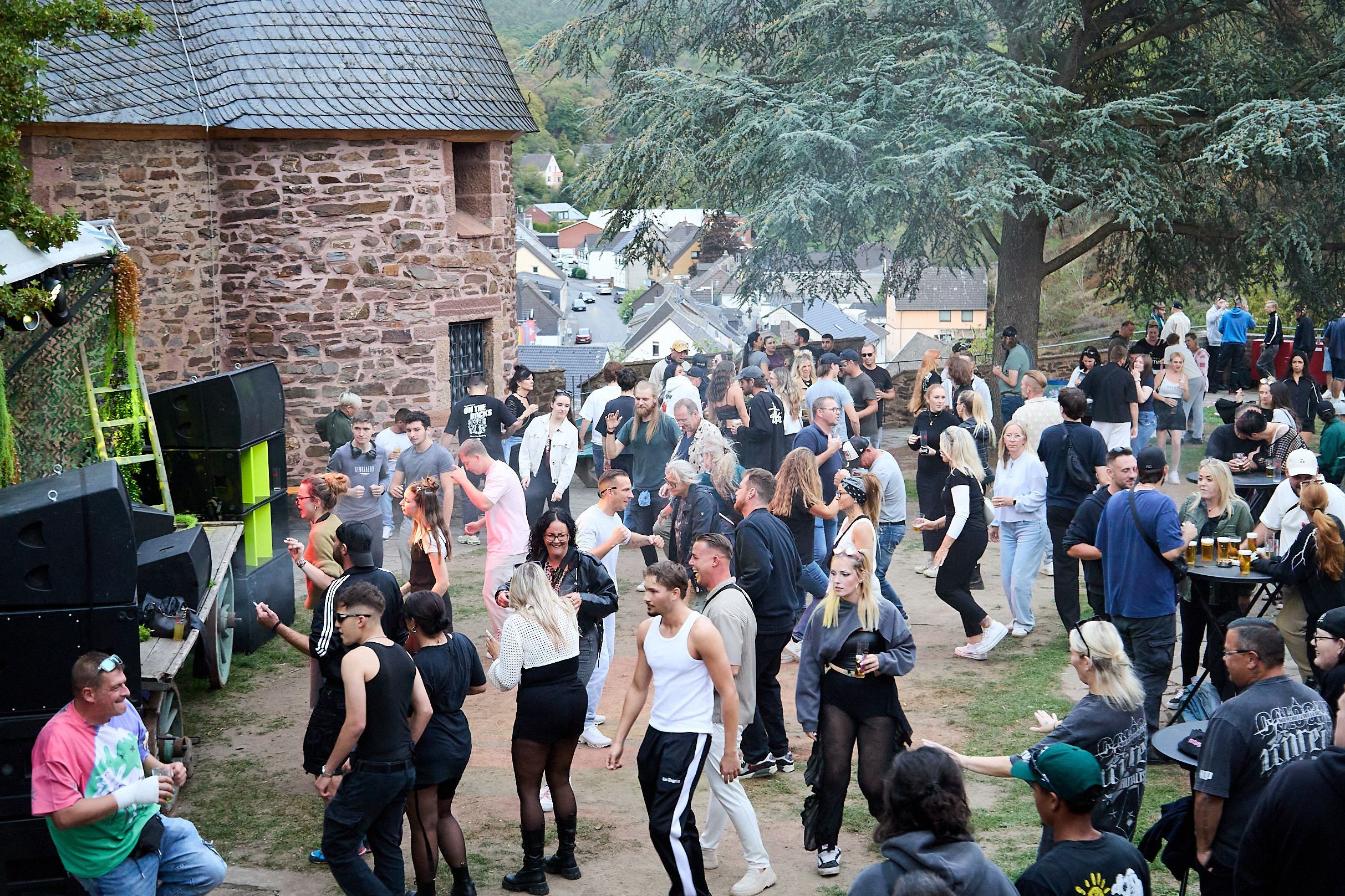 Das Bild zeigt zahlreiche Raver im Hof der Burg Hengebach in Heimbach.