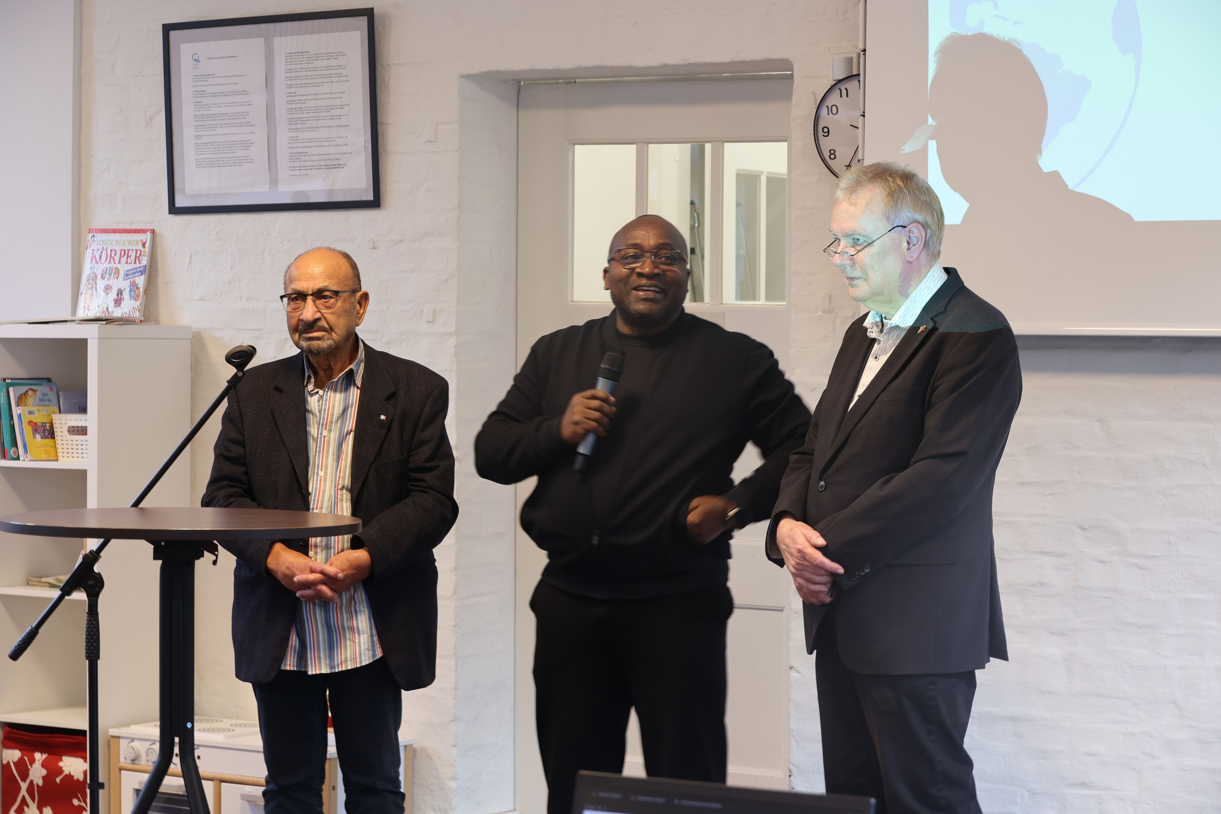 Der Vorsitzende von Interlev, Jannis Goudoulakis, Kulturreferent Kofi Nyantaki, Ralf Schiefer von der City-Kirche am Mikrofon