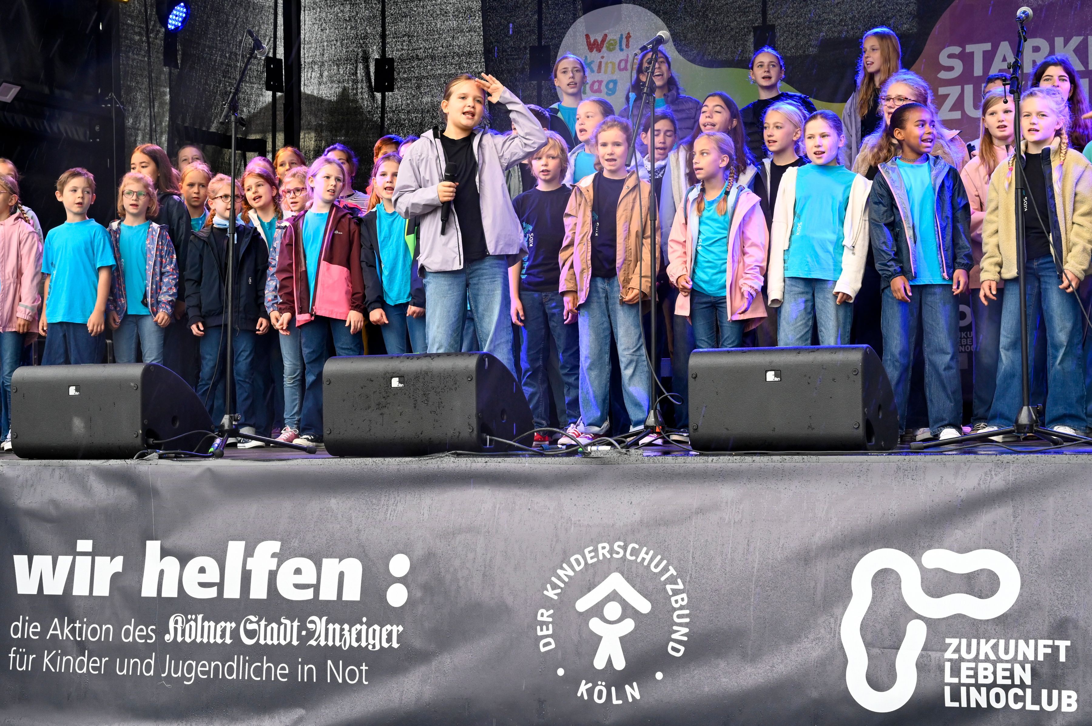 20.09.2026, Köln: Der Lucky Kids Chor singt für die Kinder. Der Weltkindertag wird mit einem großen Familienfest im Rheinauhafen gefeiert. Das Wetter ist leider regnerisch und windig. Foto: Uwe Weiser