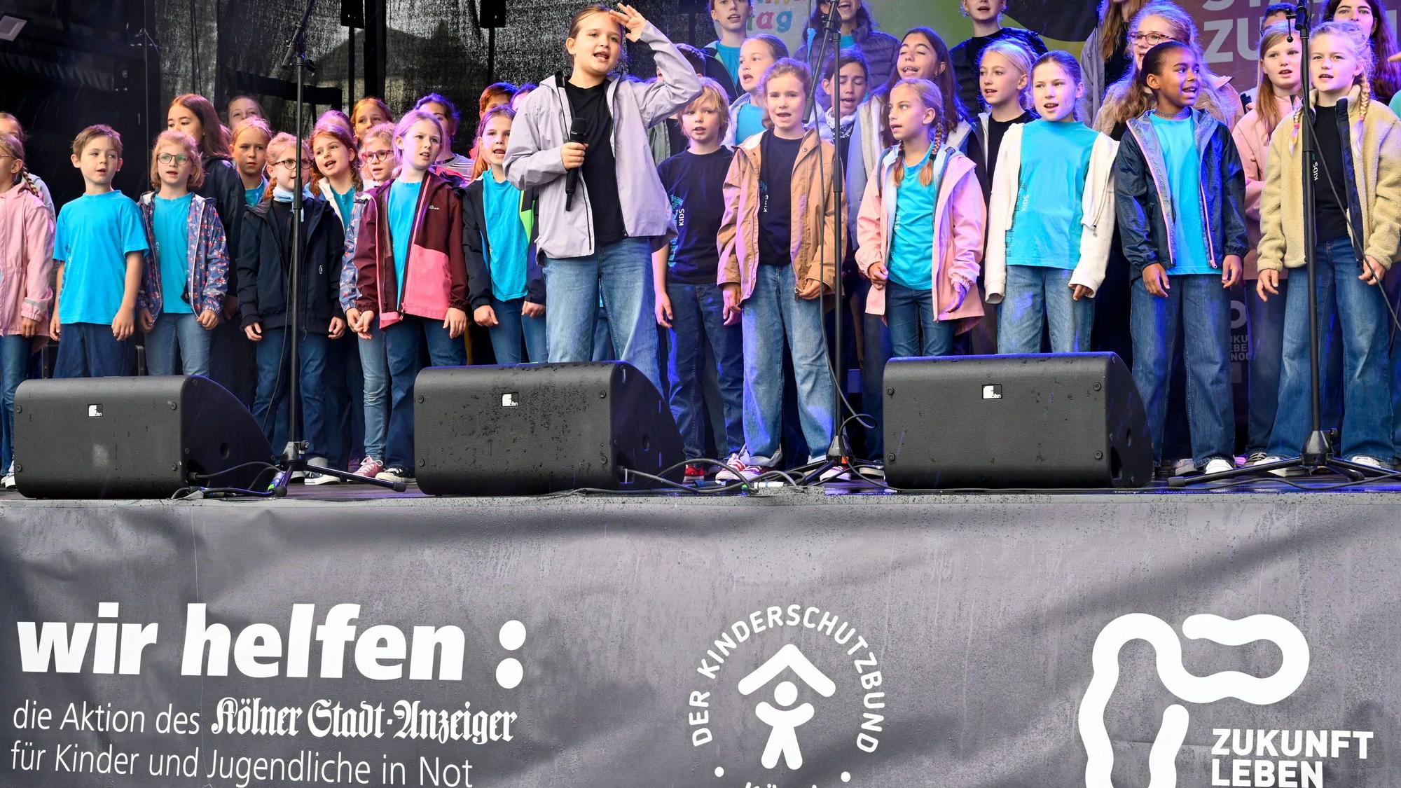 20.09.2026, Köln: Der Lucky Kids Chor singt für die Kinder. Der Weltkindertag wird mit einem großen Familienfest im Rheinauhafen gefeiert. Das Wetter ist leider regnerisch und windig. Foto: Uwe Weiser