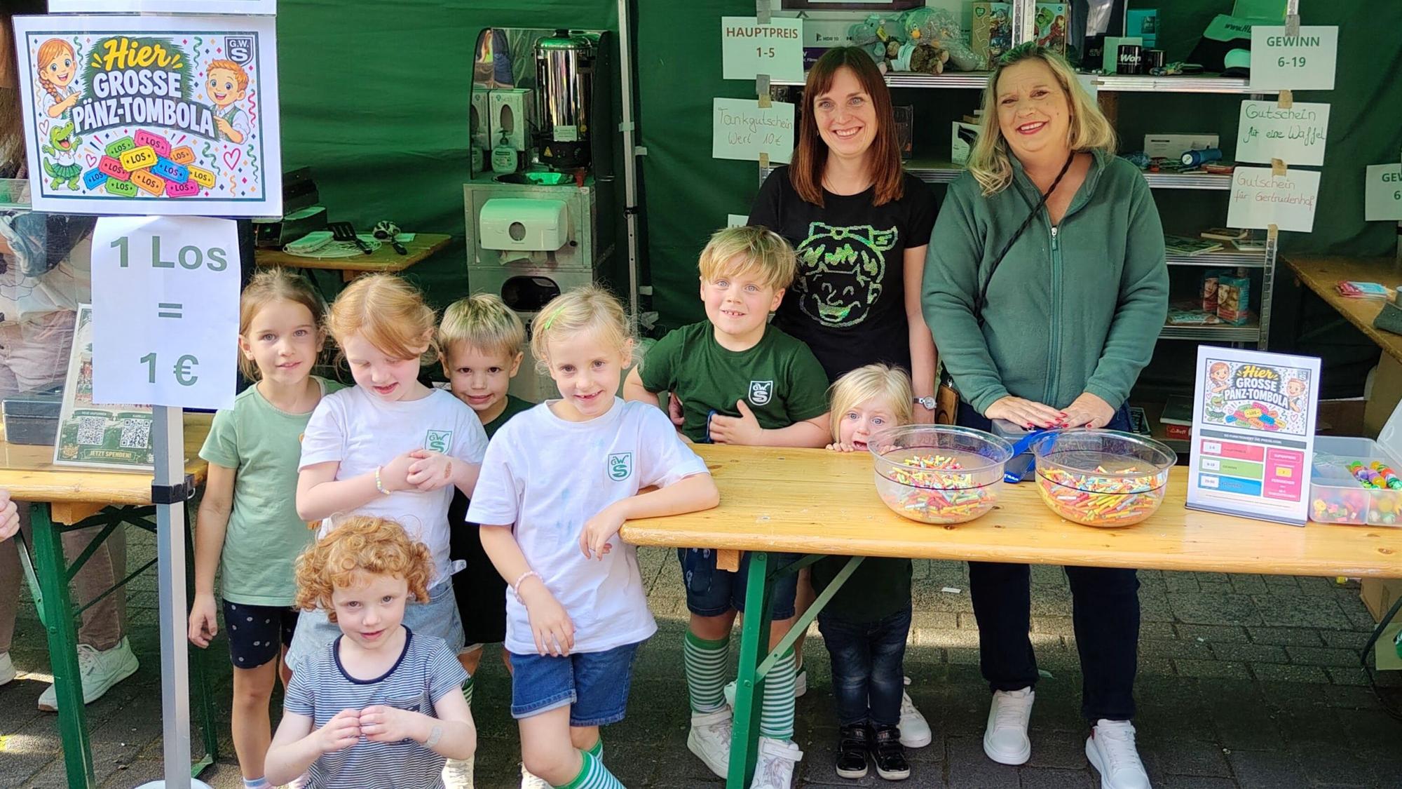 Eine Gruppe von Kindern und zwei Erwachsenen, die Geld durch eine Tombola sammeln.