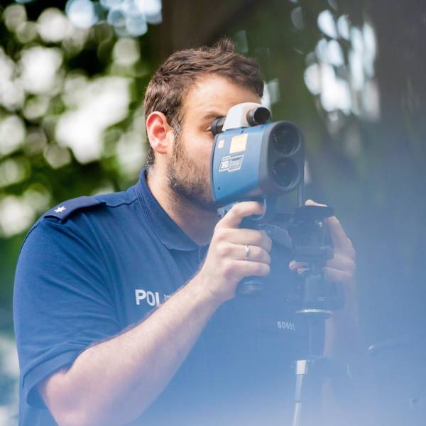 24.08.2022, Berlin: Polizeikommissar Schäfer kontrolliert bei einer Verkehrskontrolle der Berliner Polizei auf der Fulhamer Allee im Berliner Bezirk Neukölln nahe einer Schule mit einem Lasermessgerät die Geschwindigkeit des Autoverkehrs. (zu dpa: "Verkehrssünder bringen Ländern und Kommunen mehr Einnahmen") Foto: Christoph Soeder/dpa +++ dpa-Bildfunk +++