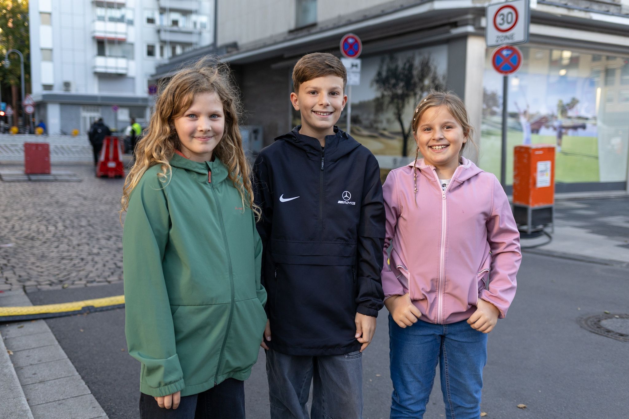 Drei Kinder stehen nebeneinander.